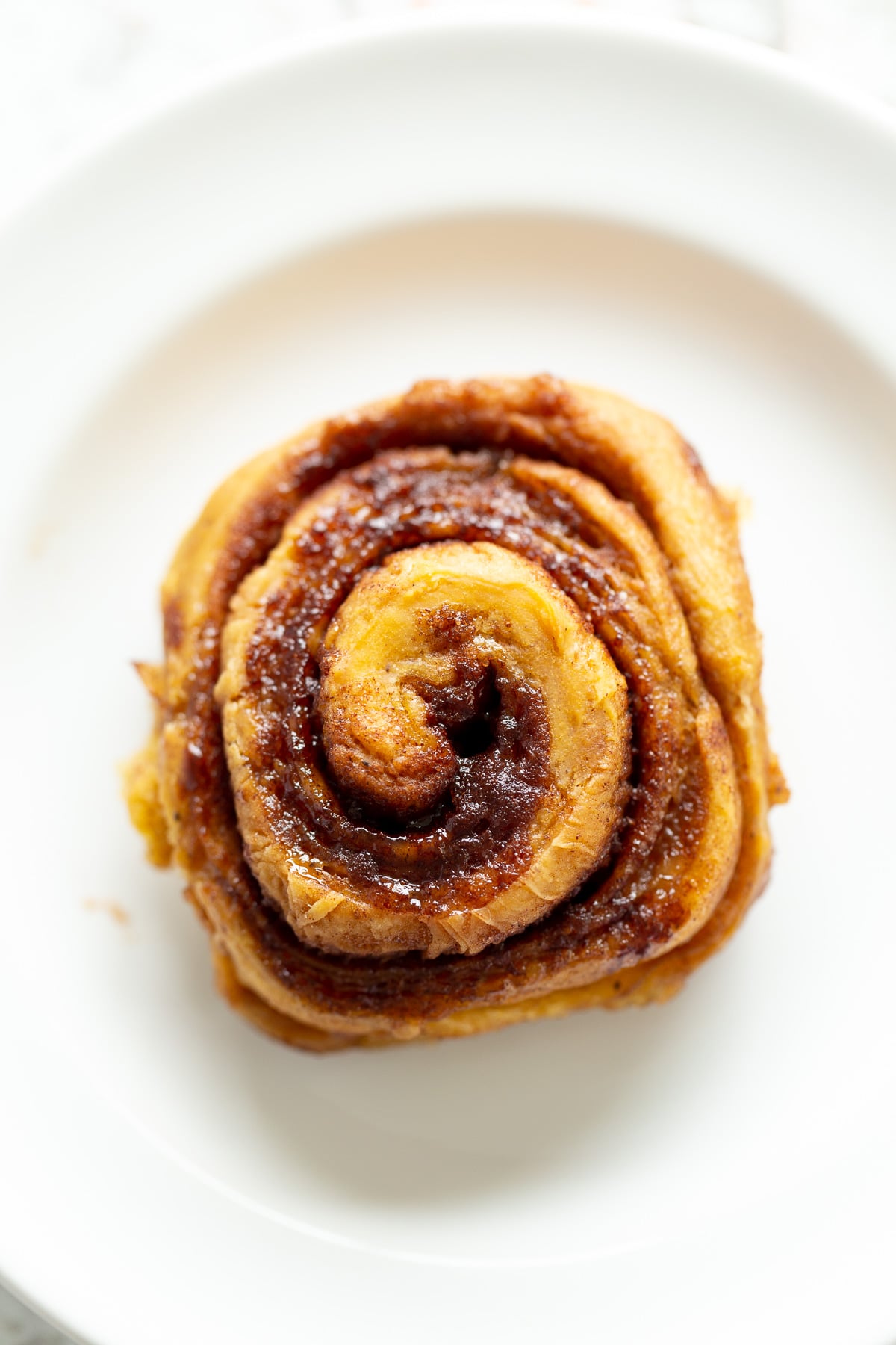 no yeast cinnamon rolls overhead shot of a vegan sweet potato no yeast cinnamon roll on a white plate