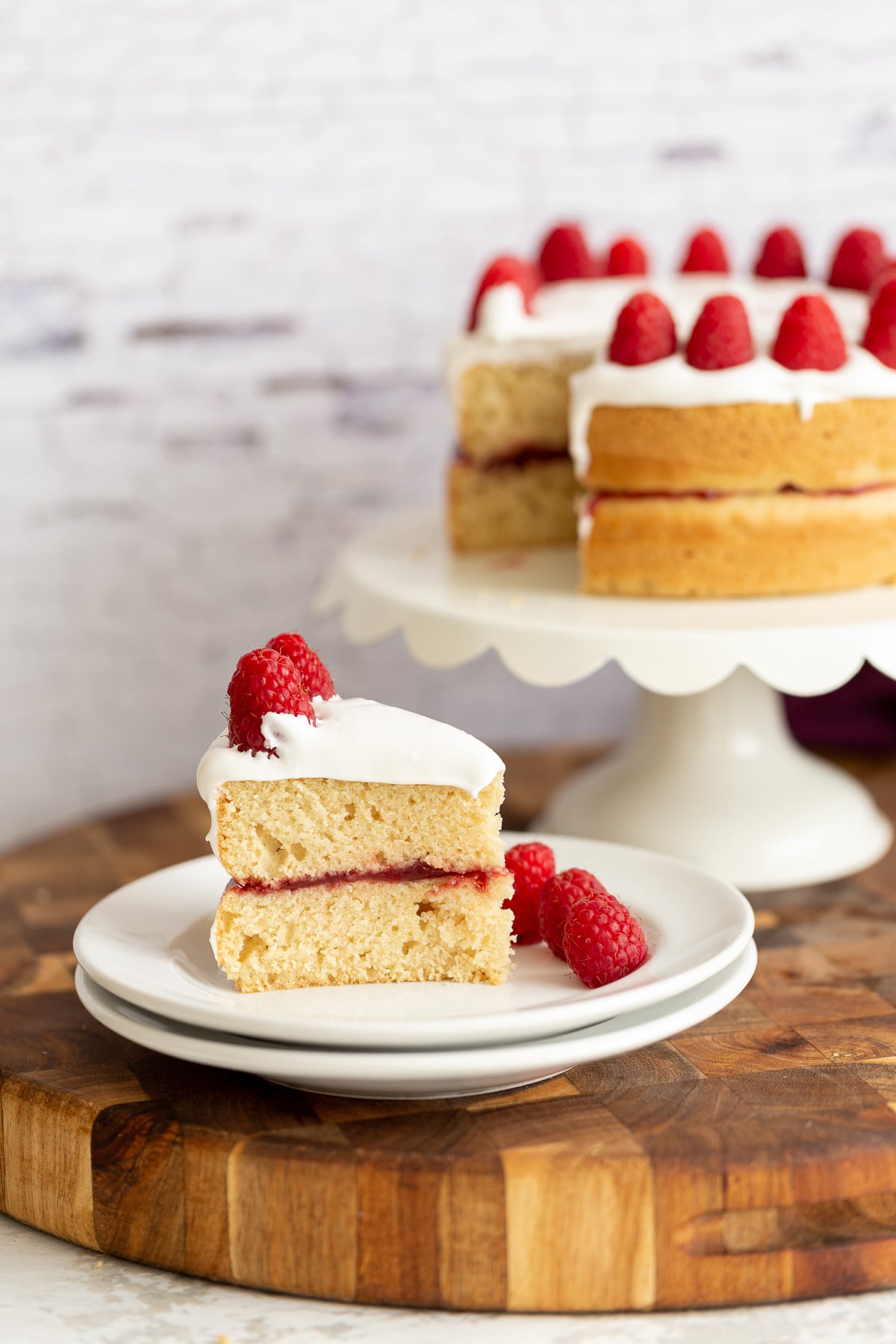 vegan white cake a slice of vegan white cake filled with raspberry preserves and topped with coconut whipped cream