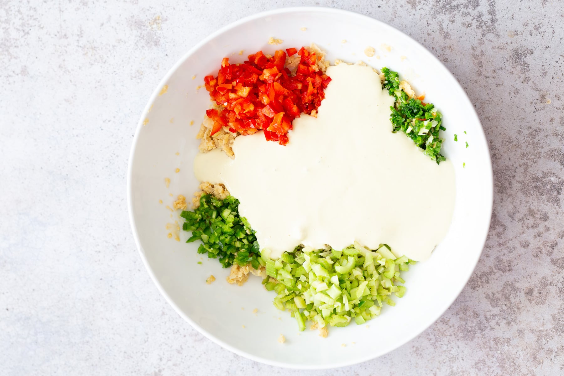 chickpea salad sandwich creamy dairy-free tofu dip being added to chickpea salad ingredients