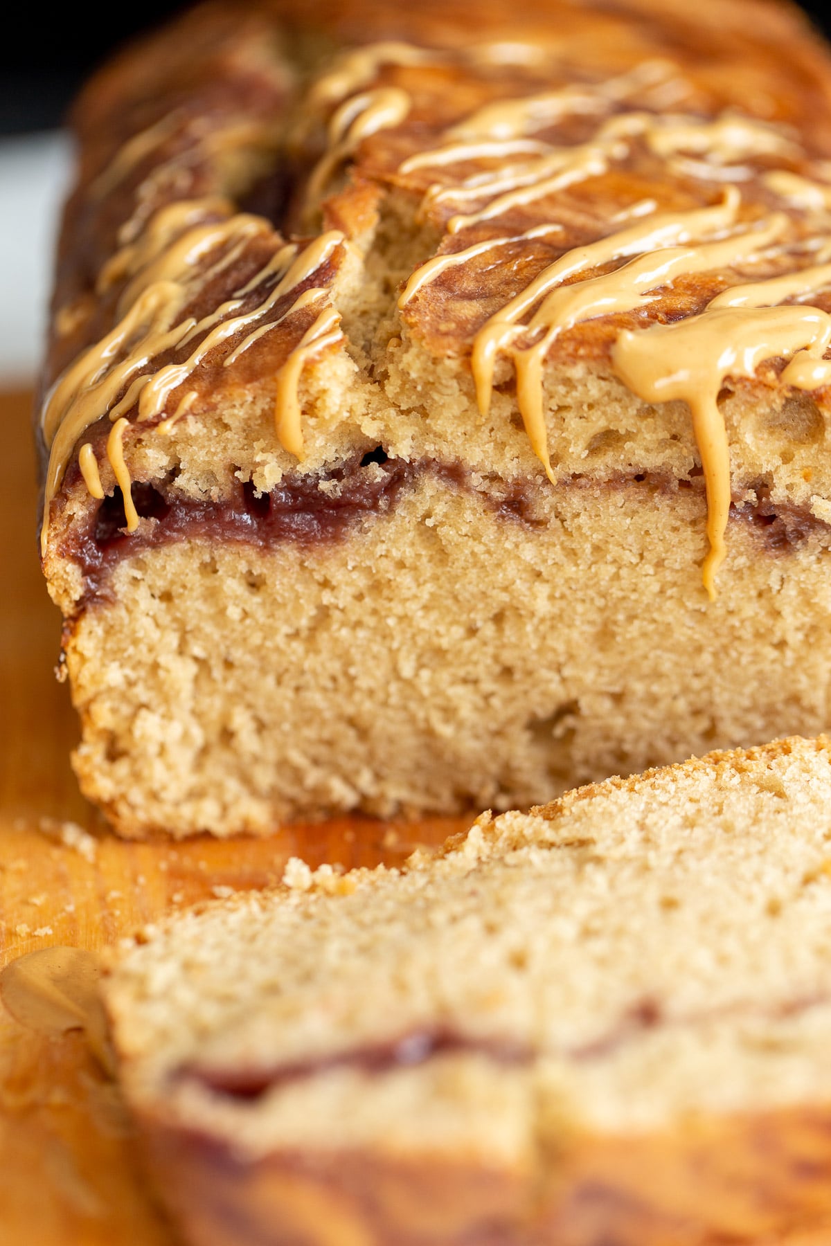 peanut butter and jelly cake close up of a sliced loaf of vegan peanut butter and jelly cake with jam swirl
