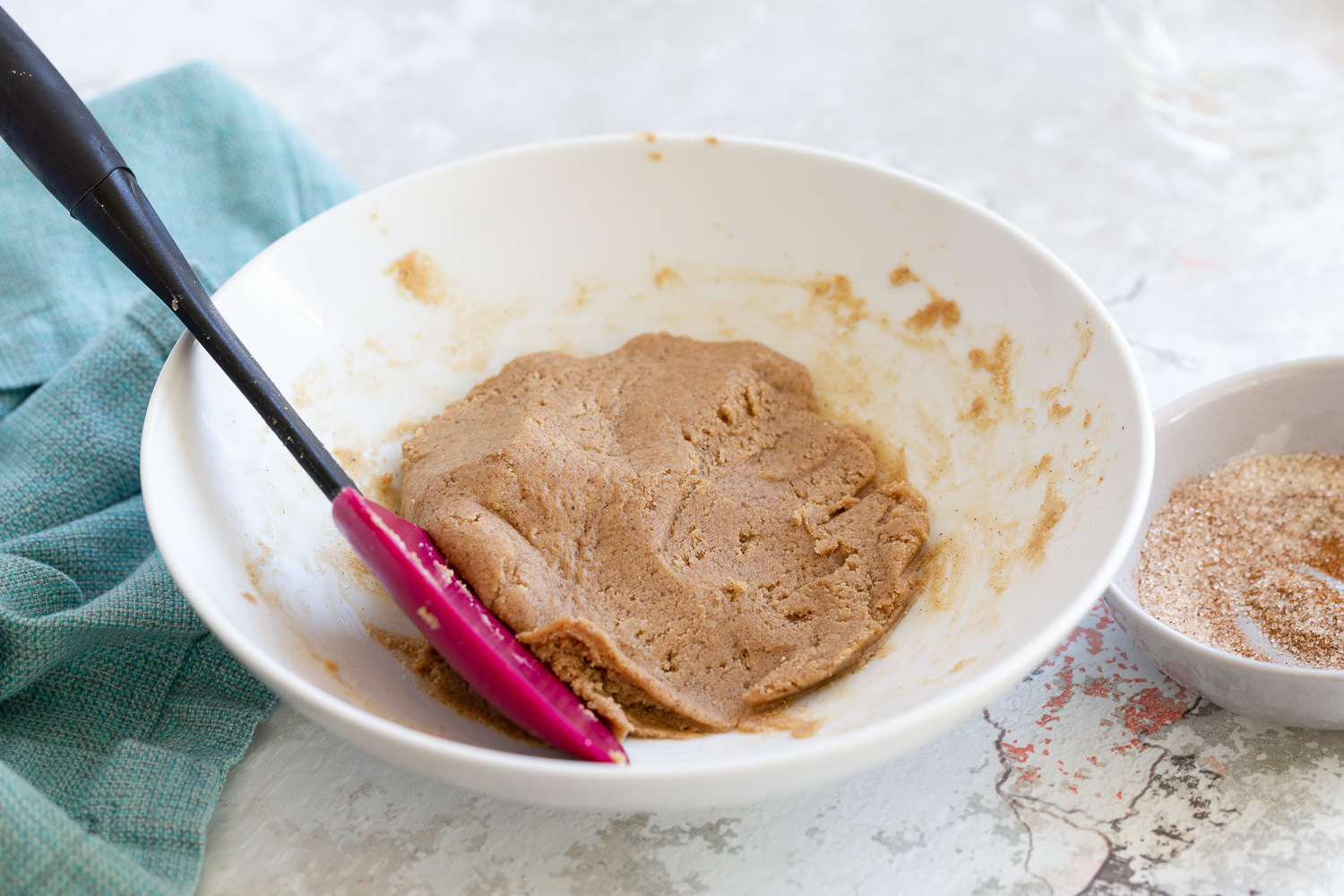 Snickerdoodle bites batter for rolling vegan Snickerdoodle bites in a white bowl