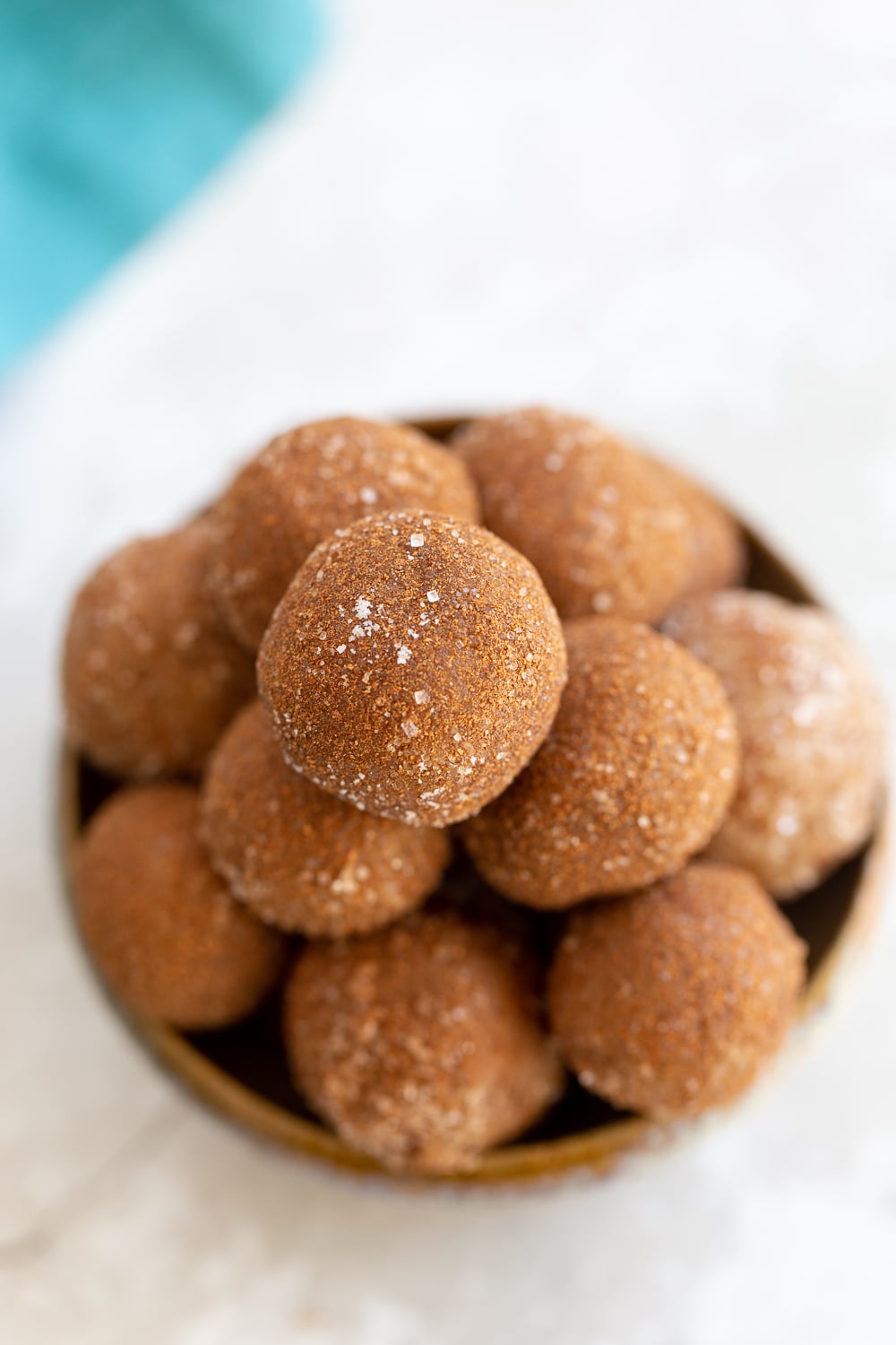 Snickerdoodle bites overhead shot of a clay bowl with vegan Snickerdoodle bites rolled in cinnamon sugar