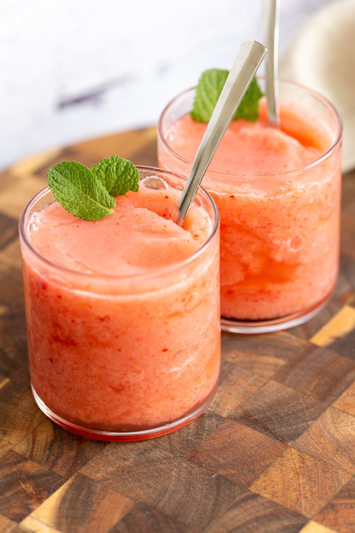 two vegan strawberry lemonade slushies decorated with mint leaves 