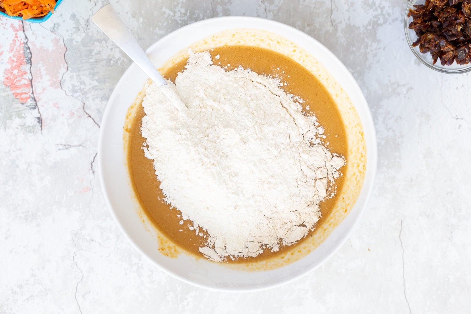 vegan carrot bread flour being added to vegan carrot pumpkin bread batter