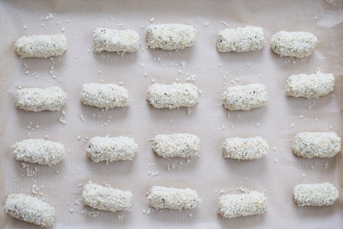 vegan croquettes unbaked vegan quinoa chickpea croquettes rolled in breadcrumbs on a baking sheet