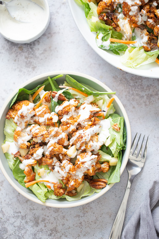 cauliflower salad overhead shot of a bbq roasted cauliflower salad bowl drizzled with Vegan Ranch Dressing