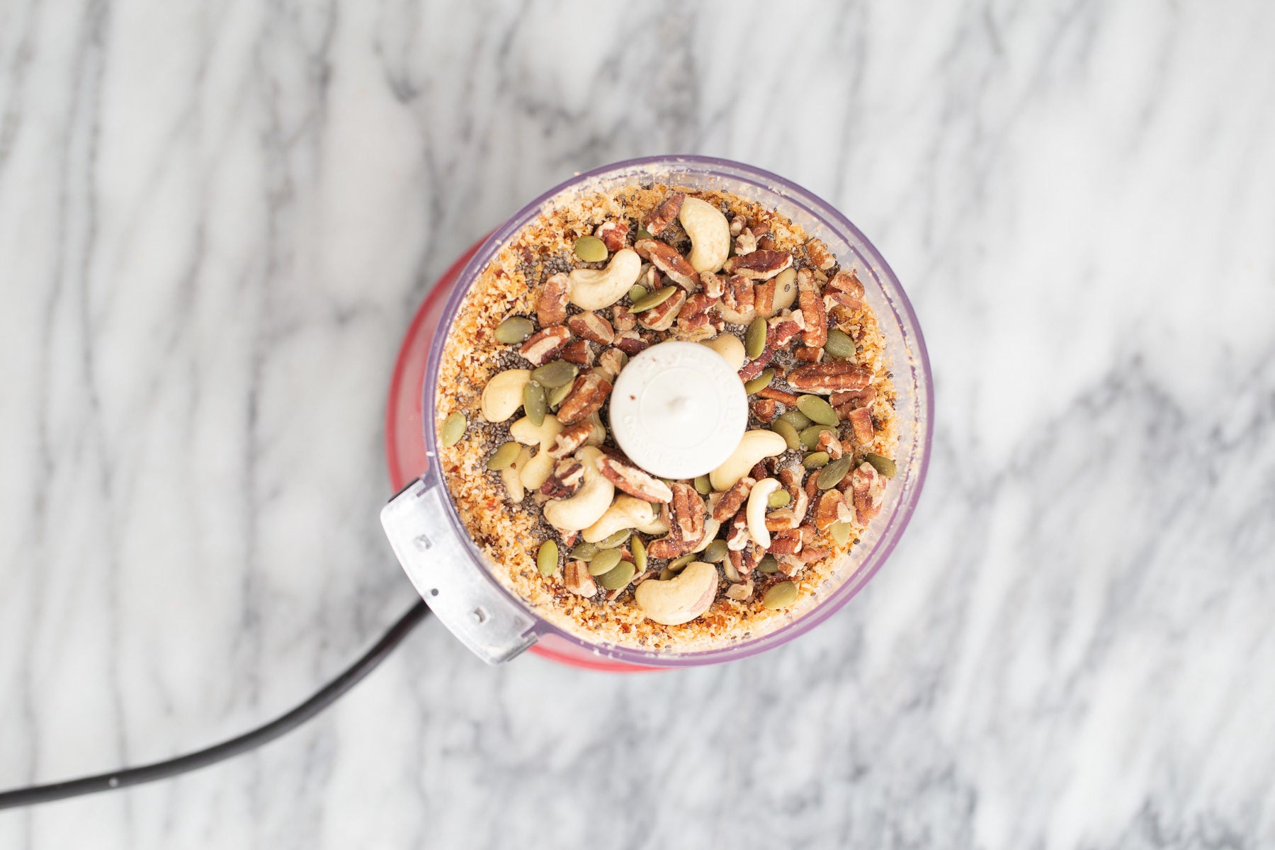 vegan date bars shredded coconuts, nuts, seeds and dates in a food processor