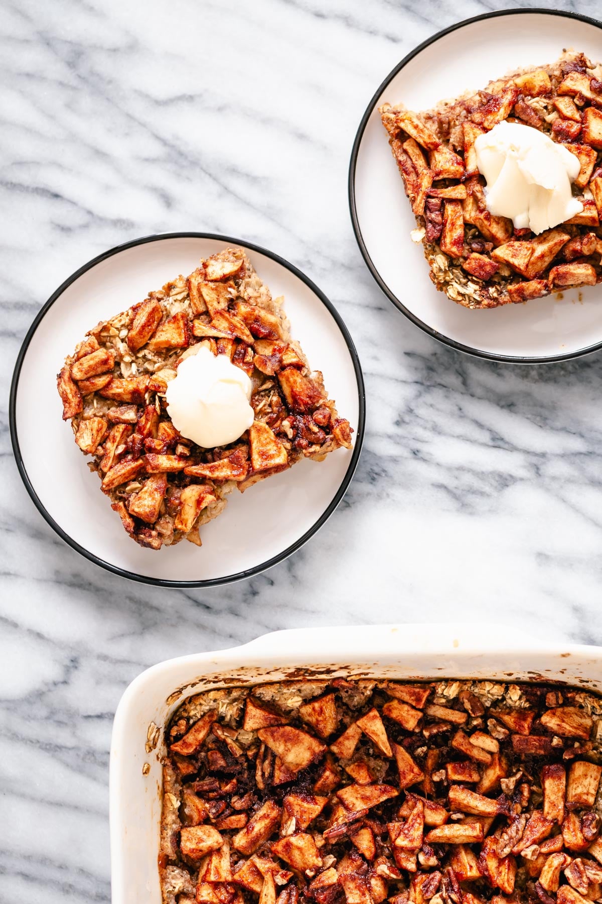 two squared of apple pie baked oatmeal served on cake plates