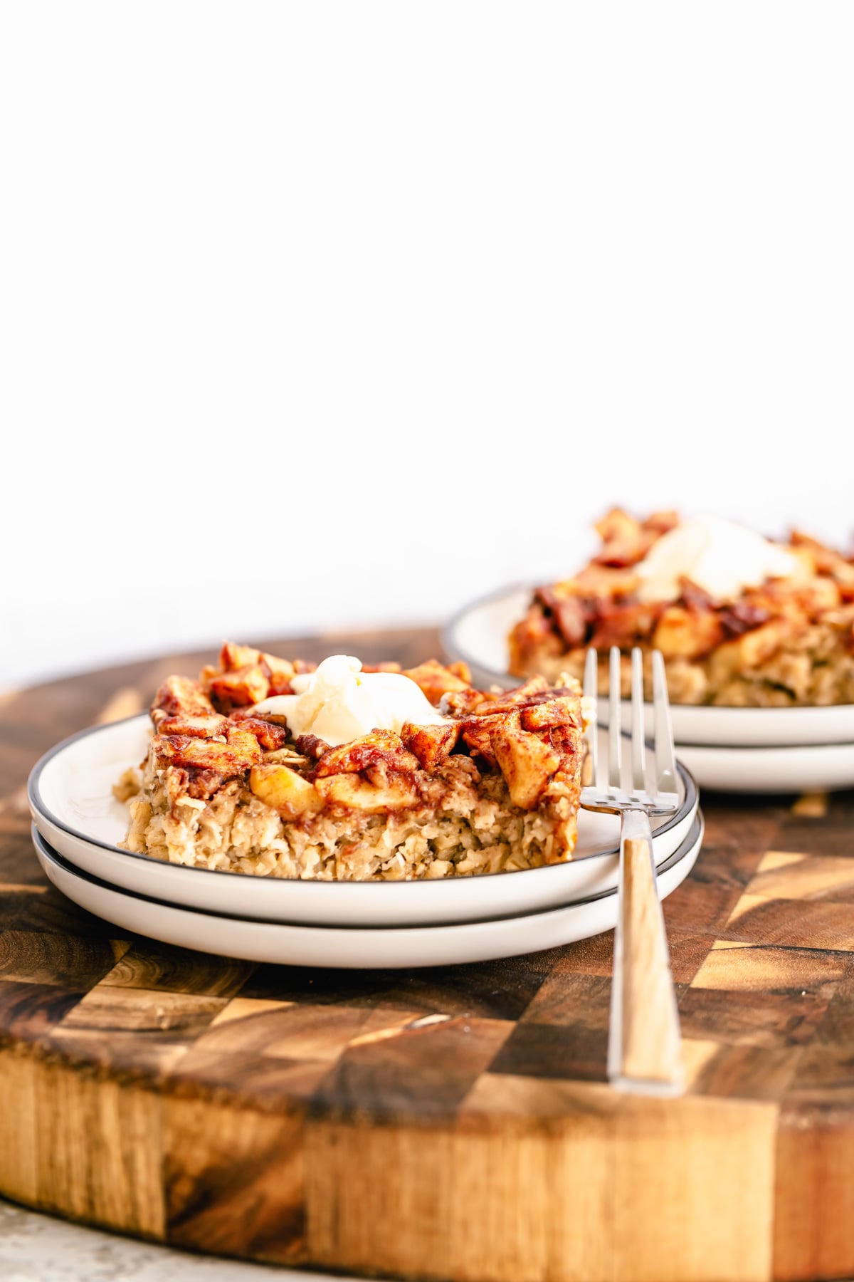 side view of a serving of vegan apple pie baked oatmeal topped with coconut whip