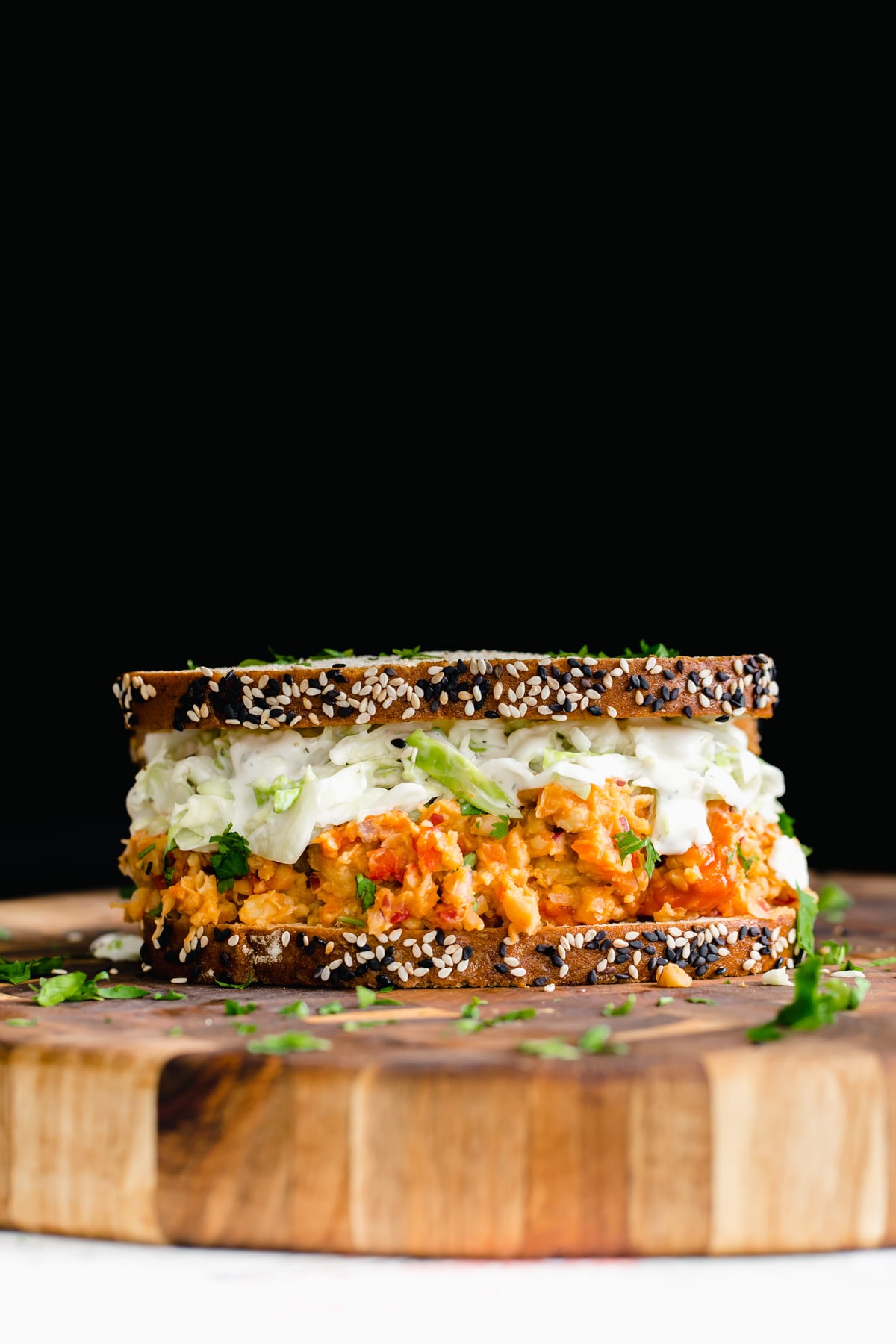side view of a vegan lunch sandwich with buffalo chickpea salad and slaw