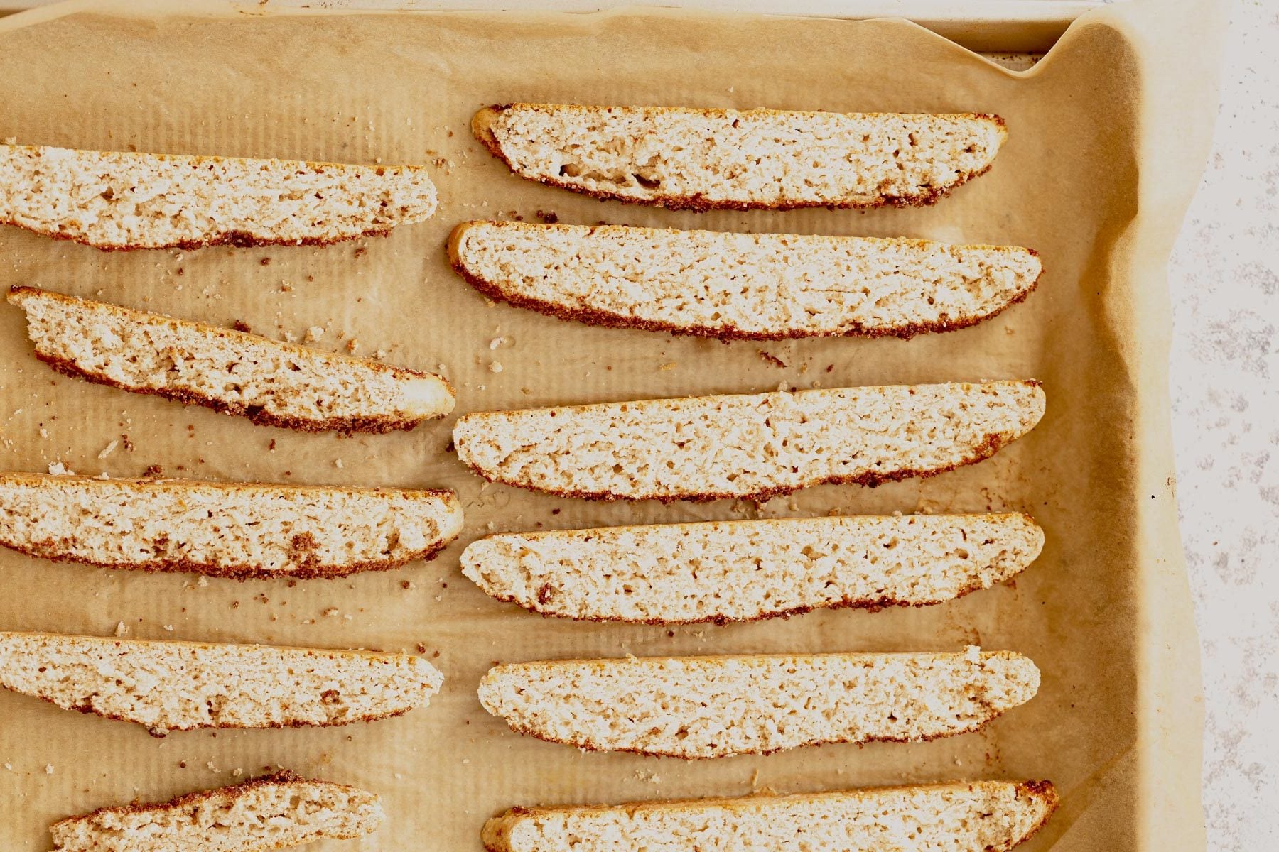 vegan biscotti vegan cinnamon sugar biscotti on a parchment paper lined baking sheet
