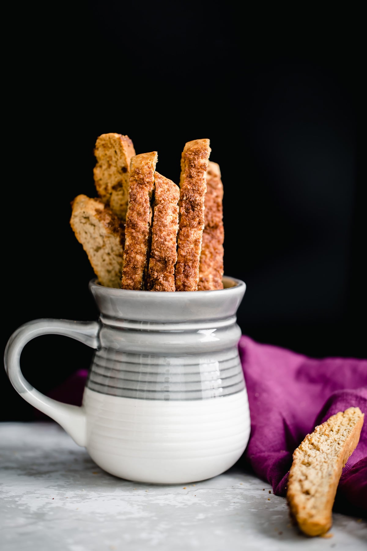 vegan biscotti homemade vegan churro biscotti peaking out of a grey and white coffee mug