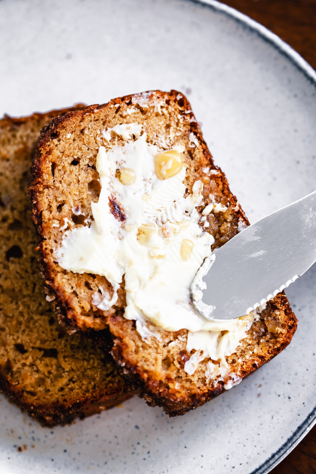 gingerbread banana bread a slice of vegan gingerbread banana bread being buttered
