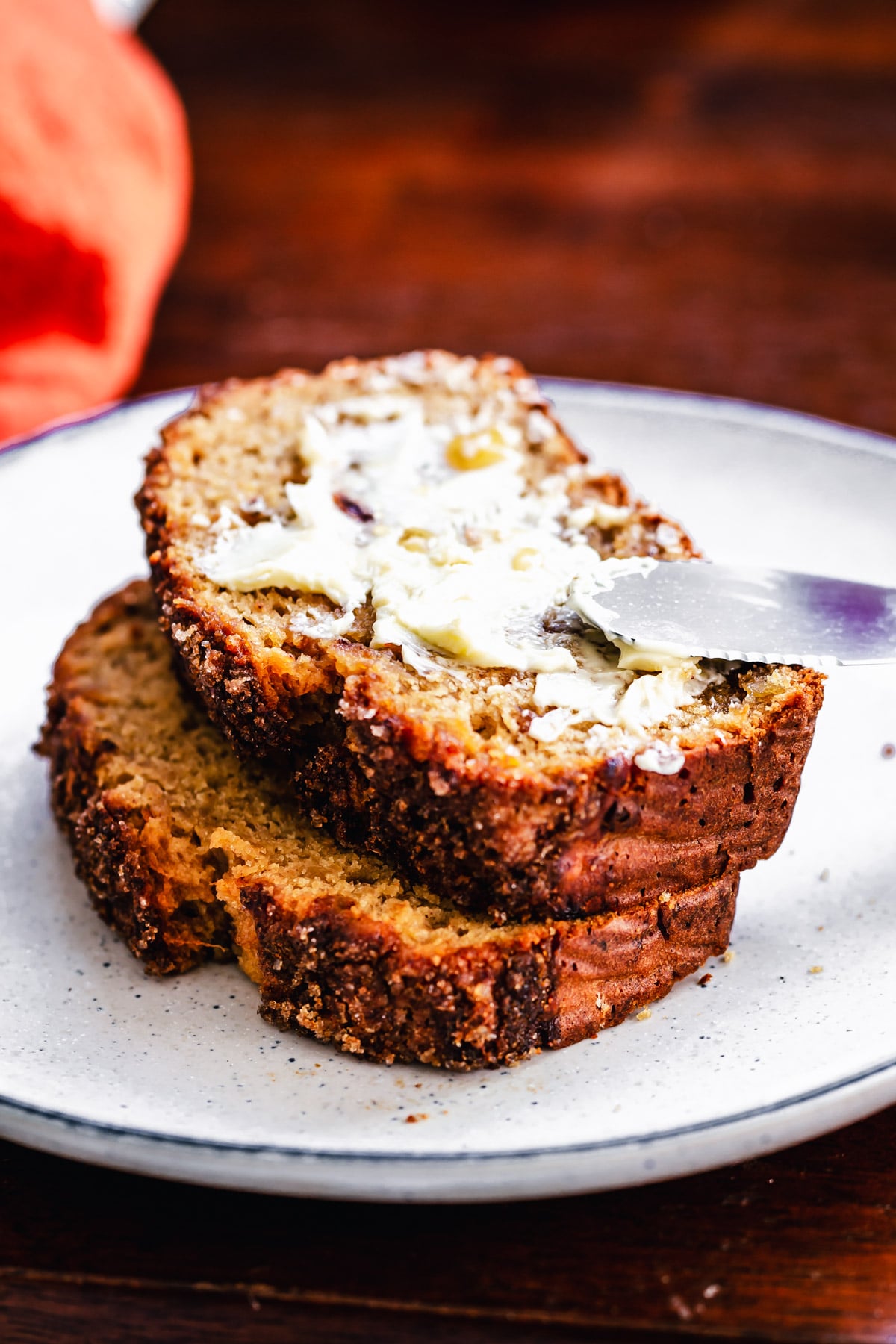 two stacked slices of vegan gingerbread banana bread slathered with butter 
