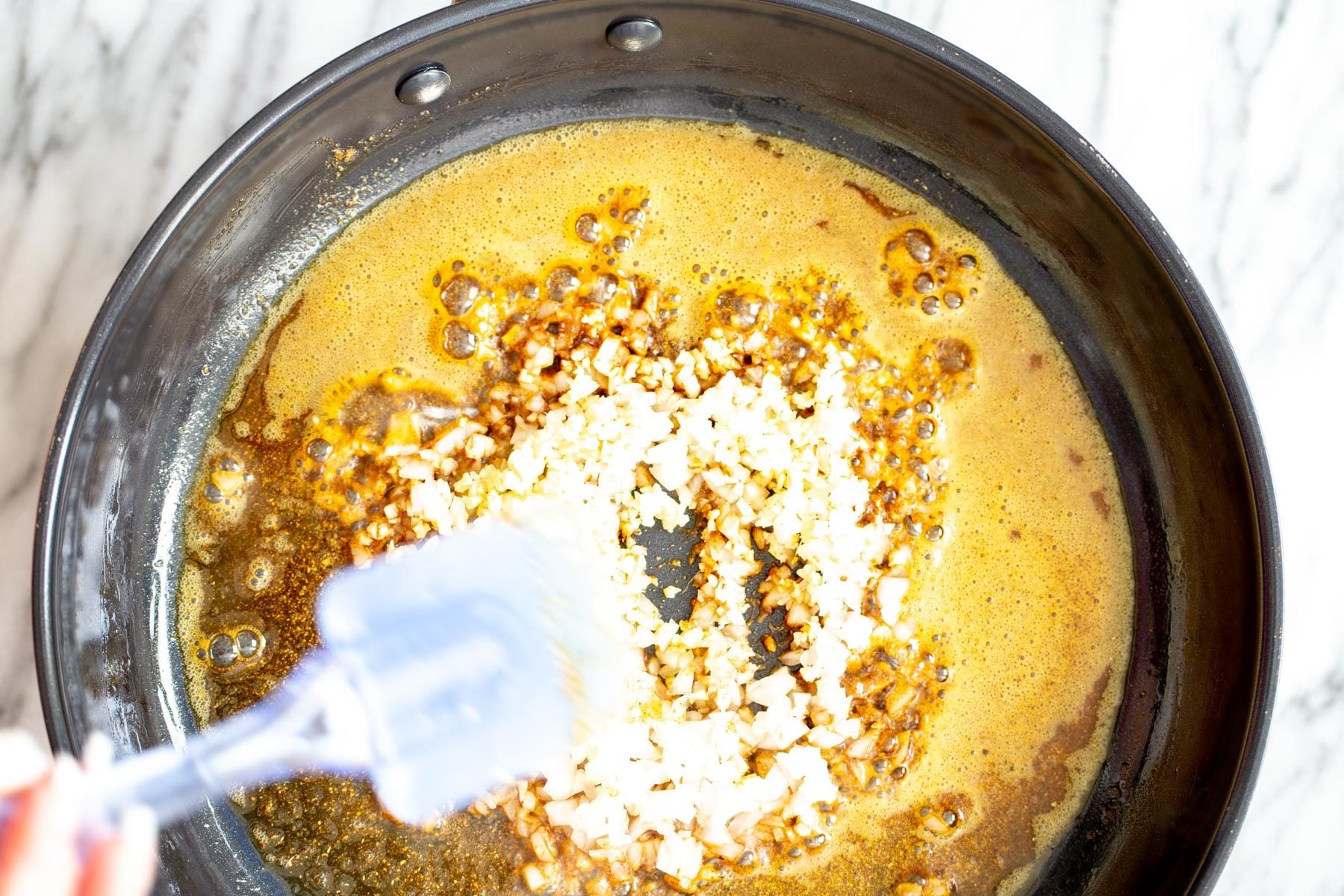 pumpkin curry overhead shot of a skillet with fried spices and onion as base for curry recipe