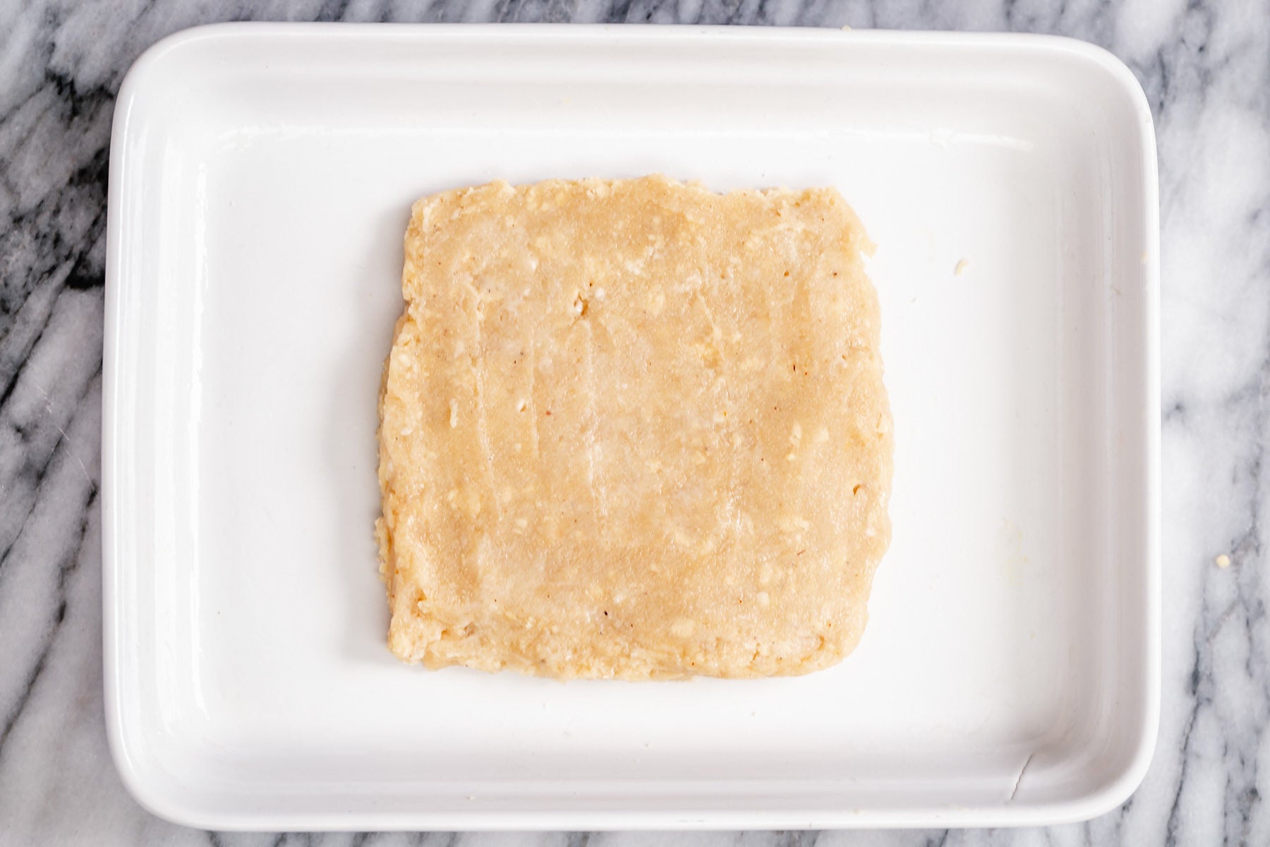 rasmalai cake rasmalai cake batter being shaped to a square in a pan