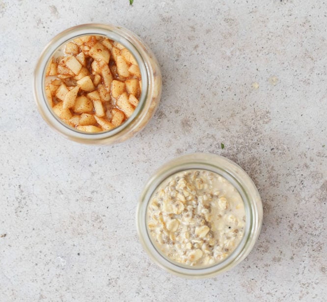 apple pie overnight oats two half filled mason jars with apple cinnamon oatmeal