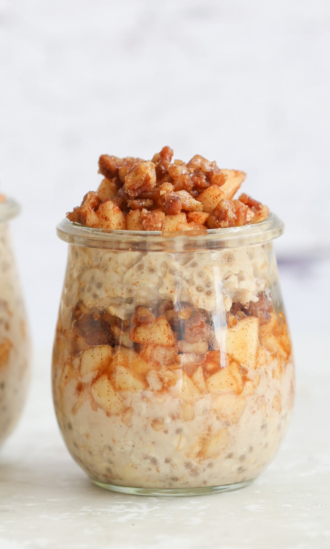 apple pie overnight oats side view of a mason jar with vegan apple cinnamon overnight oats