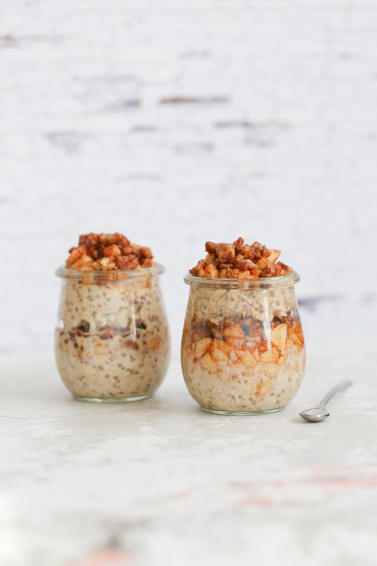 apple pie overnight oats side view of apple cinnamon overnight oats in two mason jars