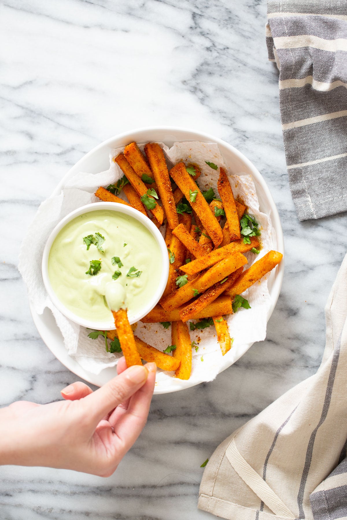 a chickpea flour frie being dipped into a cashew based cilantro lime dip 