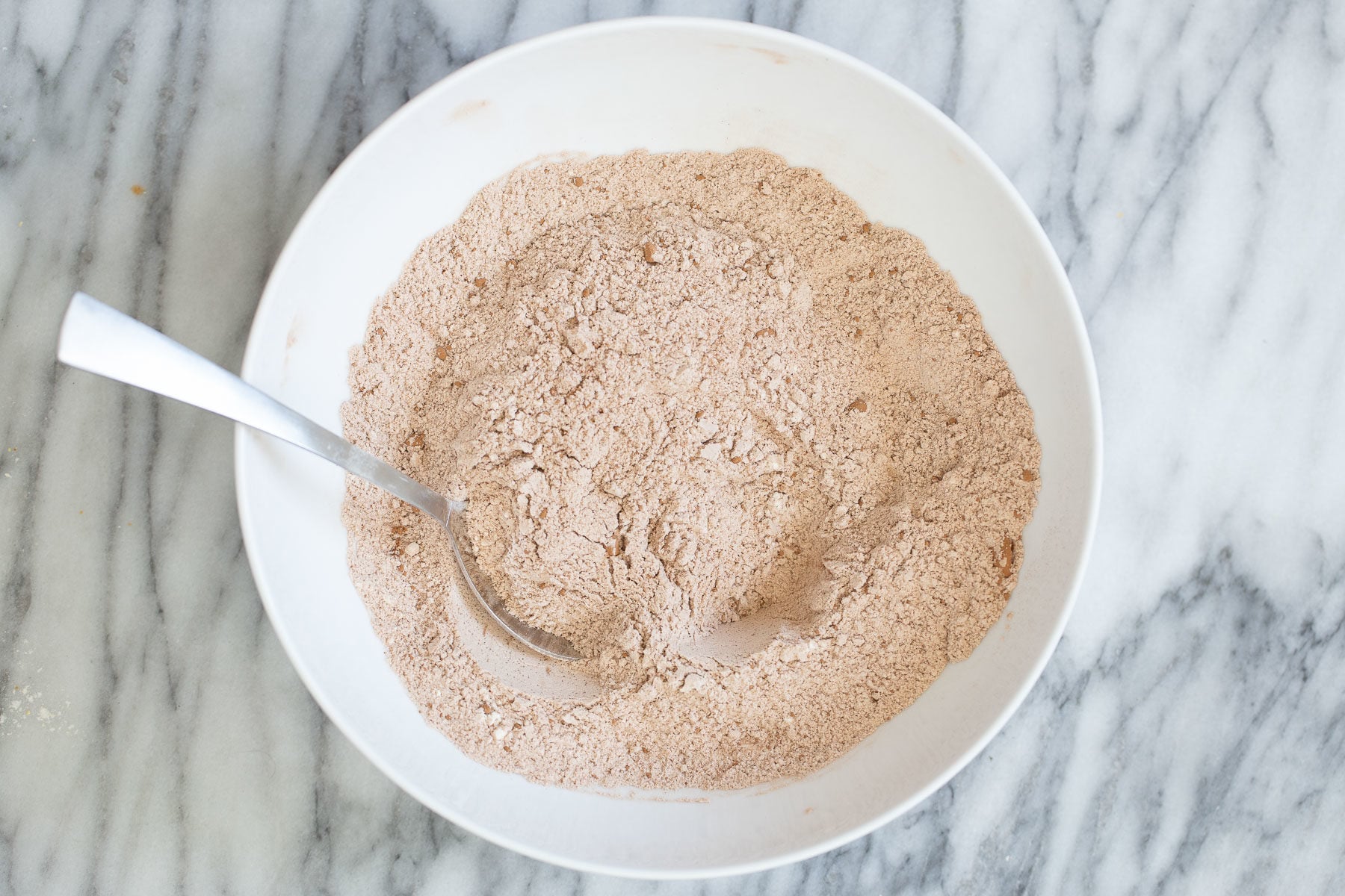chocolate zucchini bread dry ingredients for chocolate zucchini bread in a white bowl