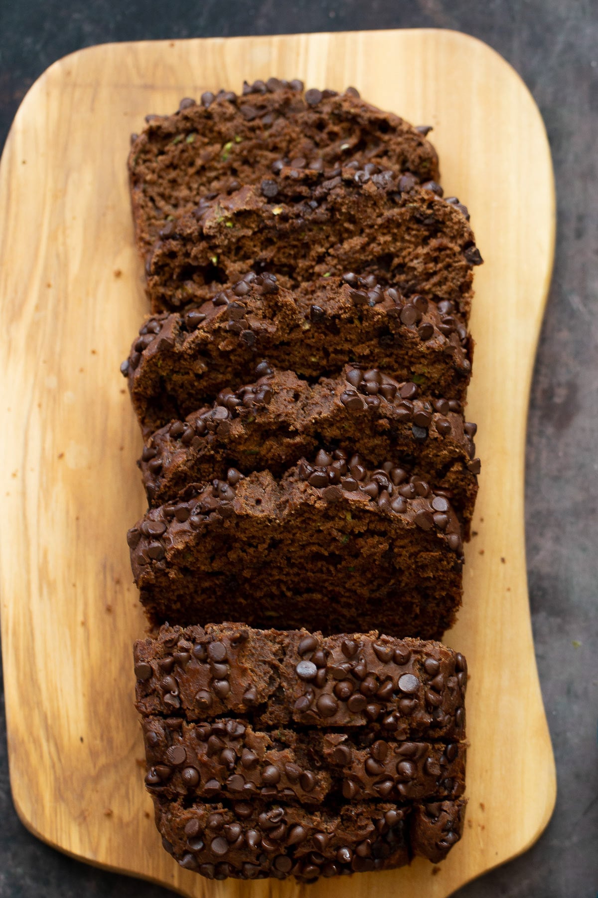 chocolate zucchini bread overhead shot of a sliced loaf of vegan chocolate zucchini bread on a wooden chopping board
