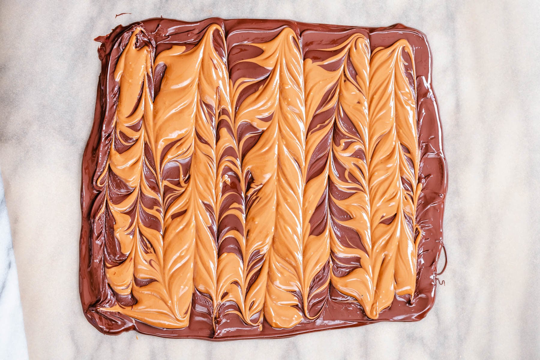 peanut butter chocolate bark peanut butter cup chocolate bark on a sheet of parchment paper