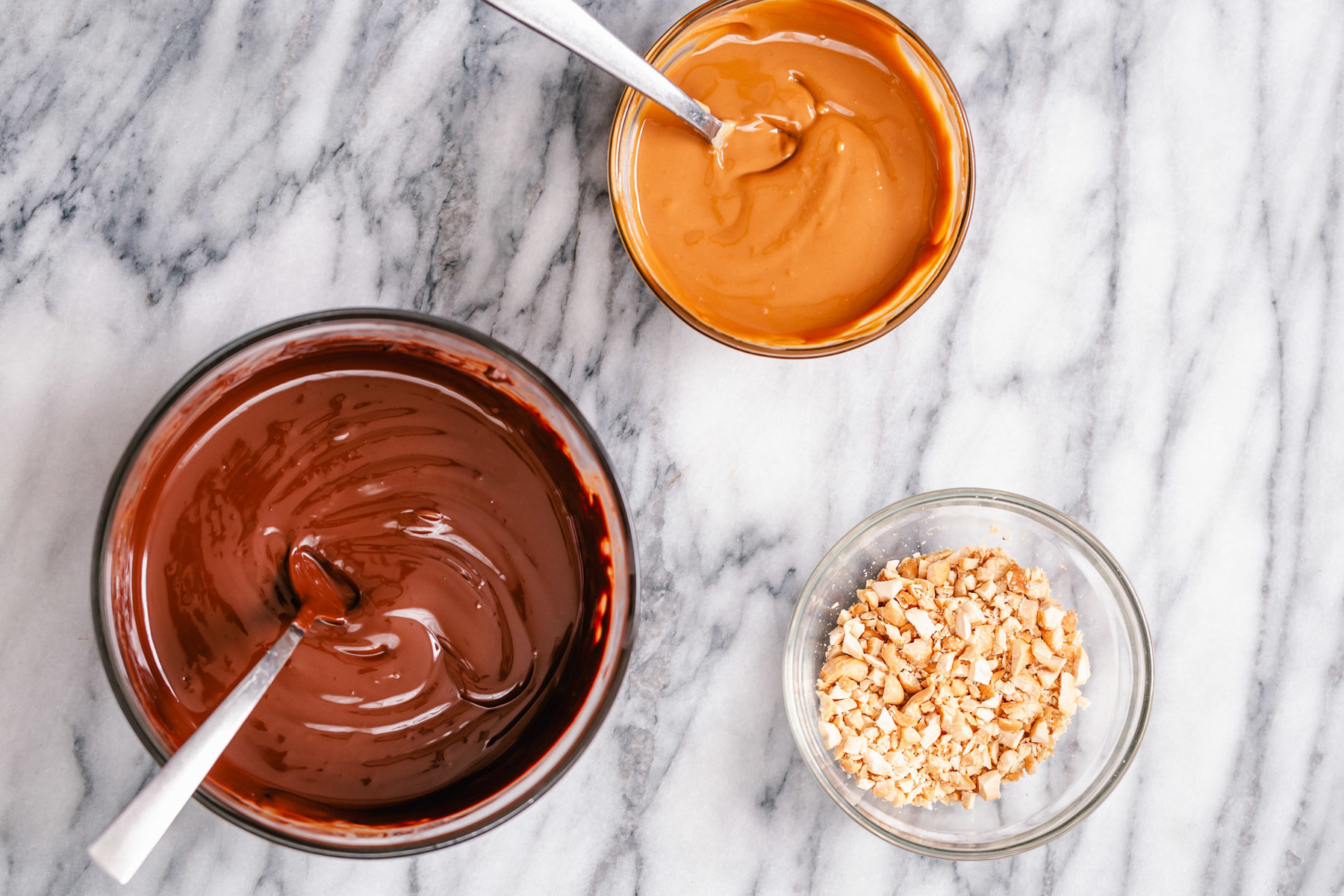 peanut butter chocolate bark melted chocolate, melted peanut butter and crushed peanuts ready for making peanut butter chocolate bark