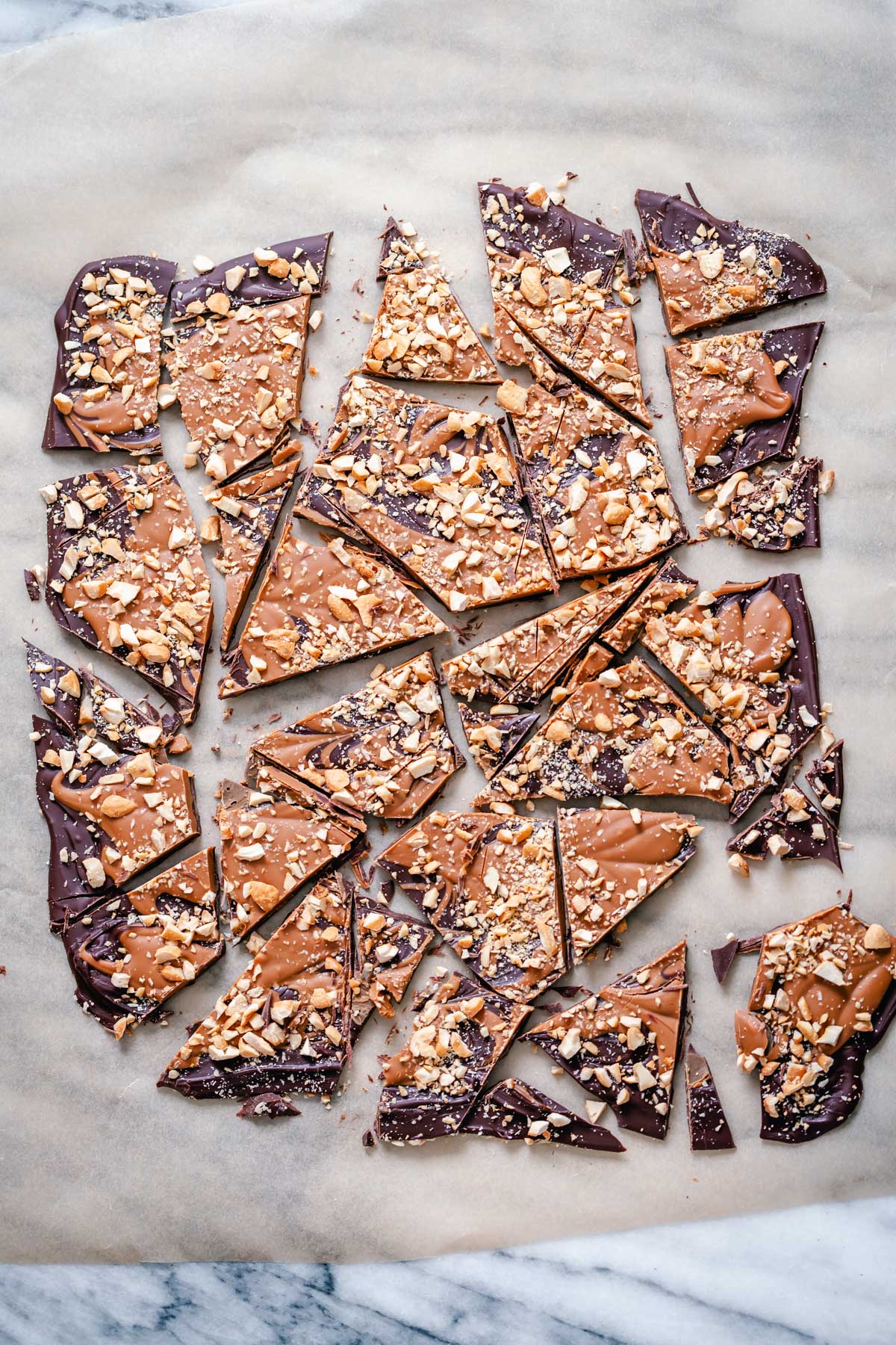 peanut butter chocolate bark overhead shot of broken up peanut butter cup chocolate bark on a sheet of parchment paper