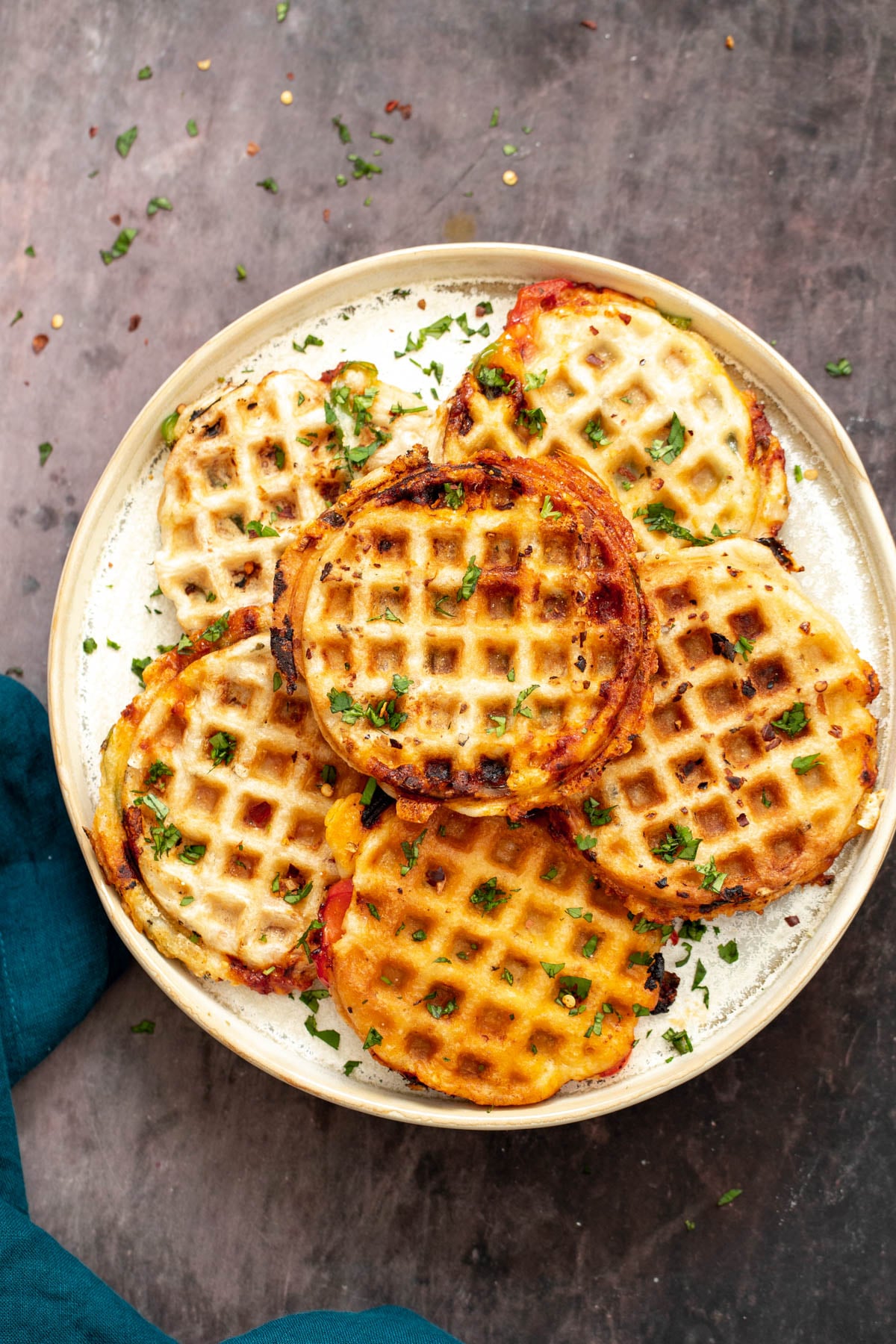 a plate with homemade vegan pizza waffles sprinkled with herbs