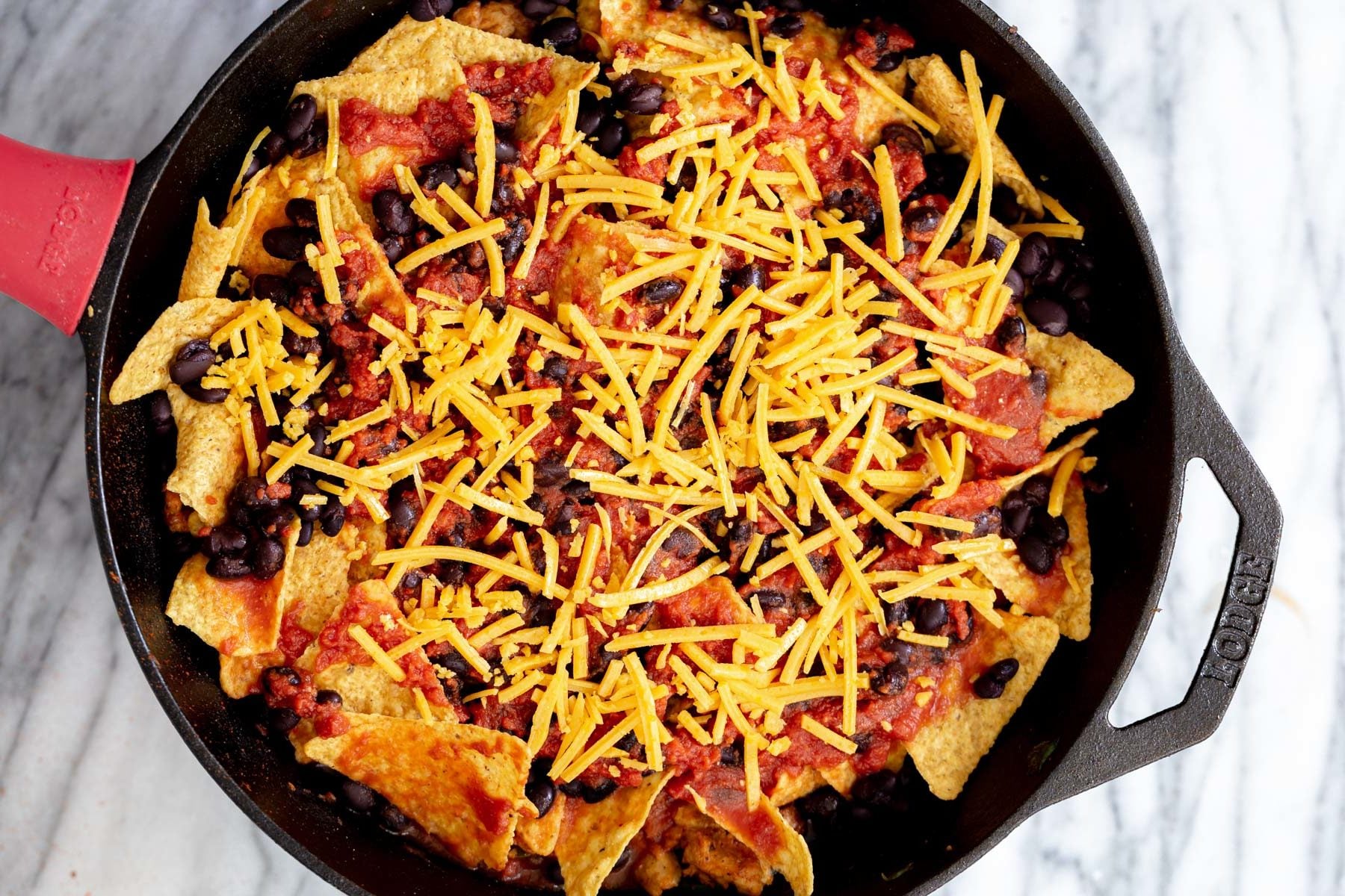 vegan skillet enchiladas vegan skillet enchiladas being topped with vegan cheese shreds