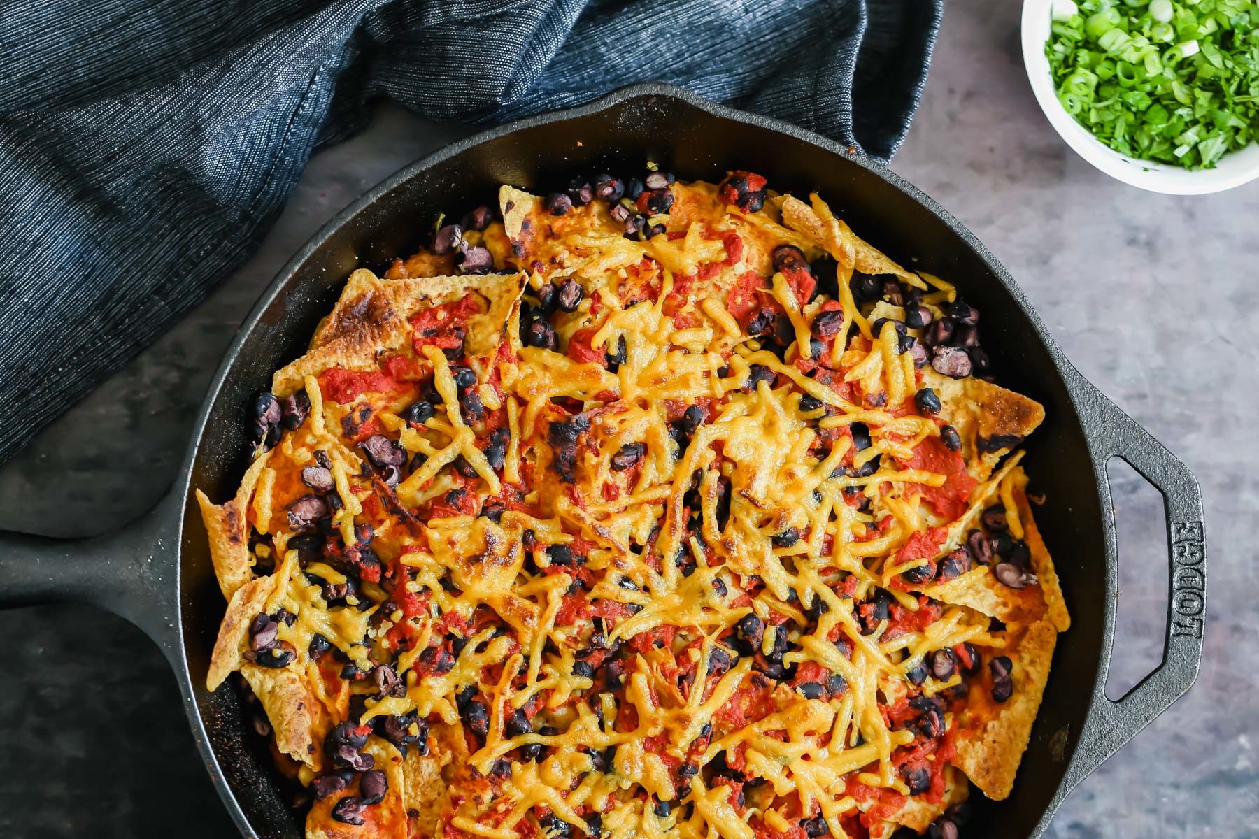 vegan skillet enchiladas vegan skillet enchiladas with red sauce and black beans next to a dish with green onions