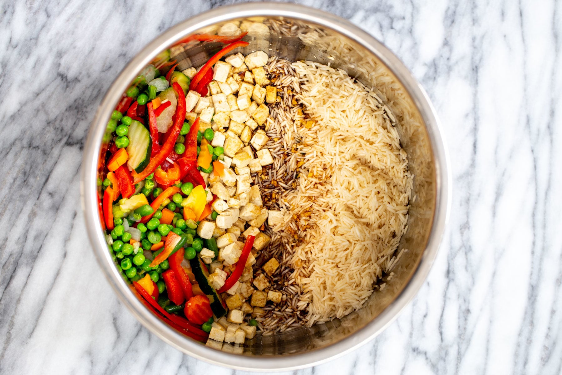 rice being mixed with teriyaki sauce, vegetables and tofu in an Instant Pot