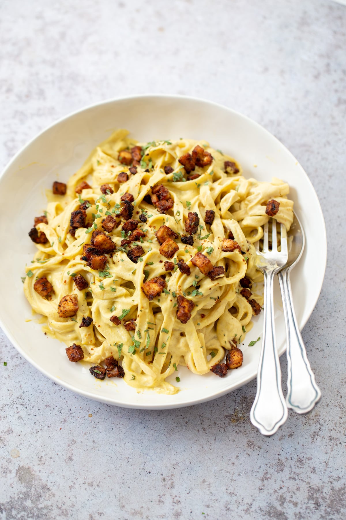butternut squash carbonara close up of a plate of vegan butternut squash pasta carbonara served with baked tofu