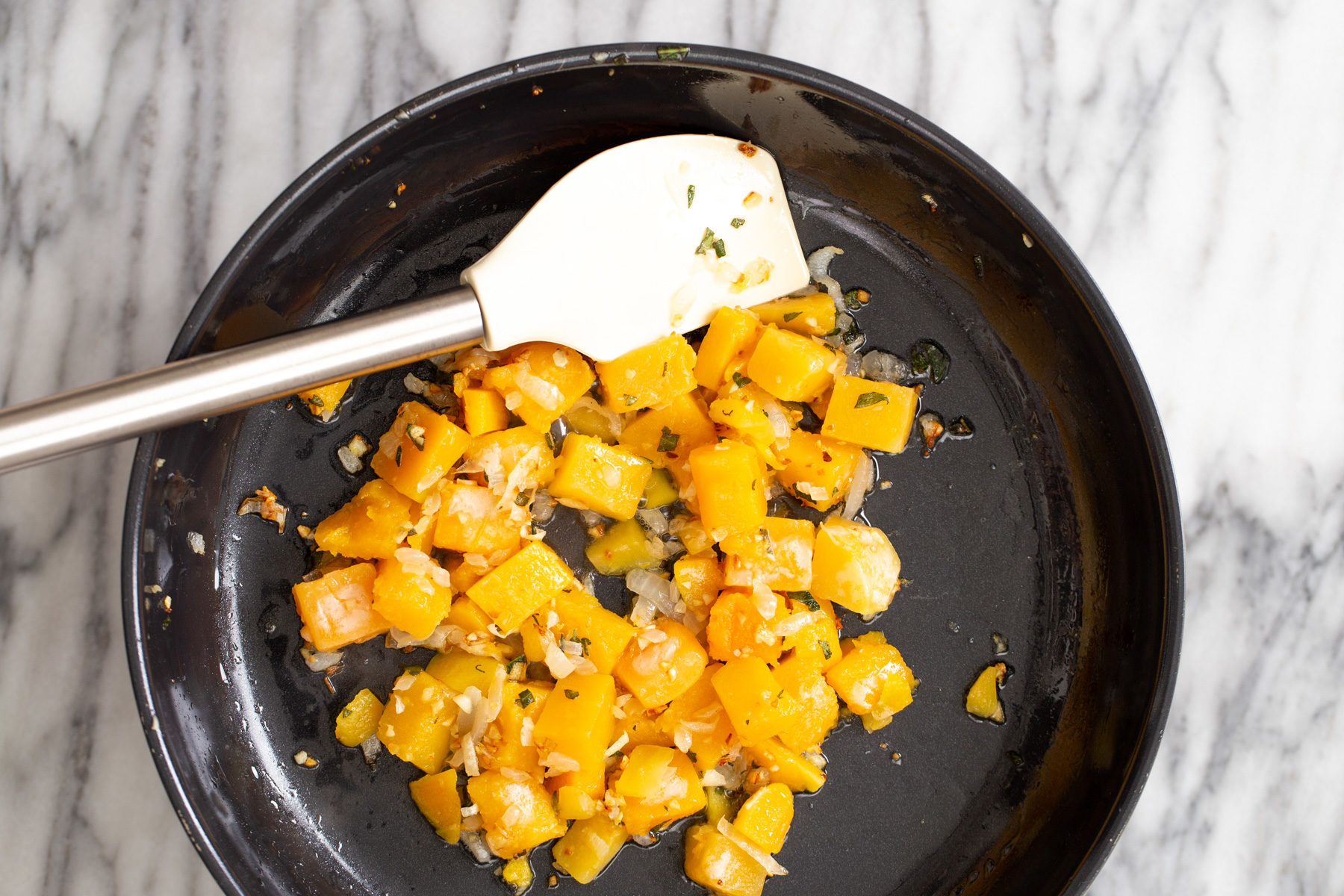 butternut squash carbonara butternut squash being sauteed in a skillet