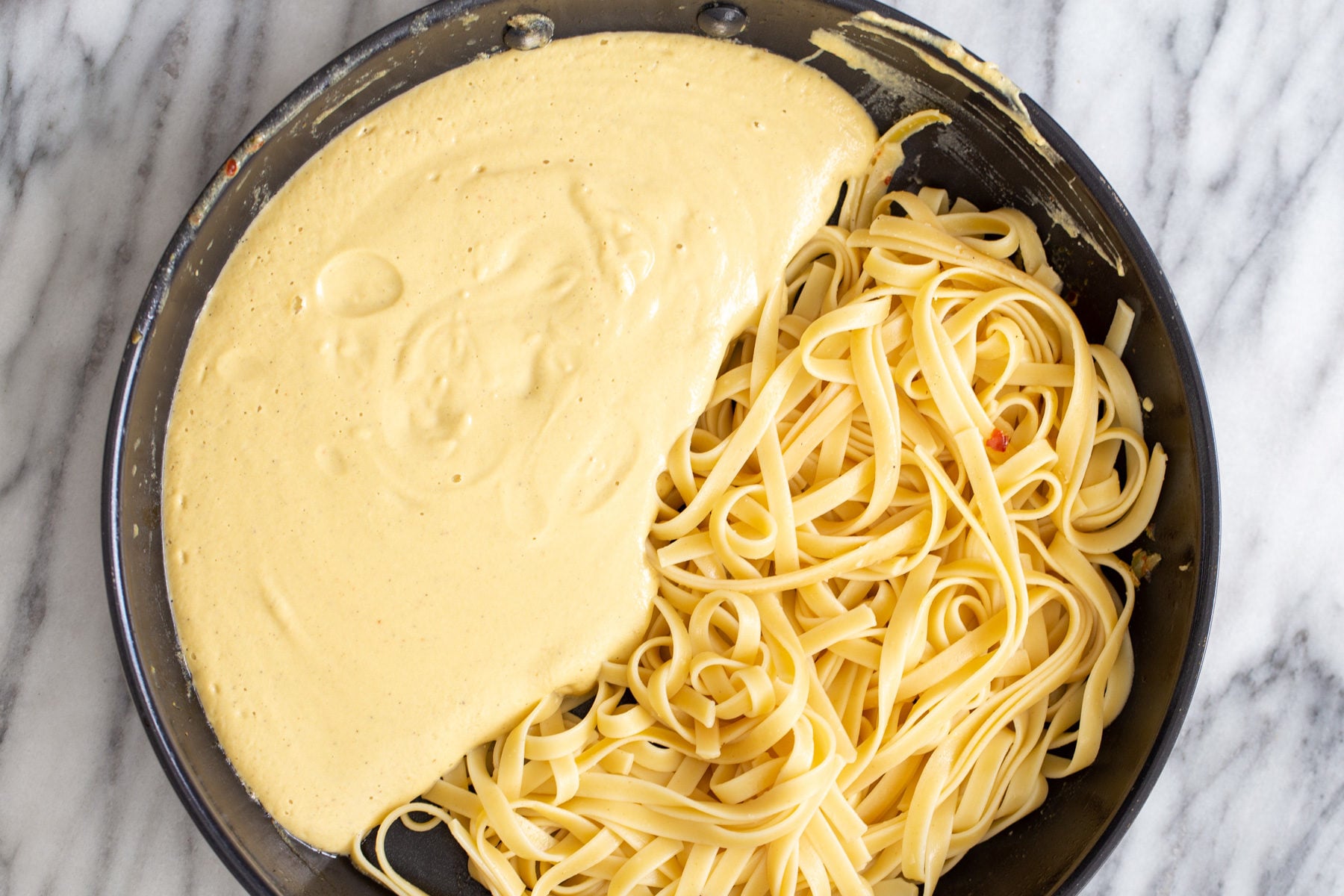 butternut squash carbonara overhead shot of a skillet with linguine with creamy butternut squash carbonara sauce
