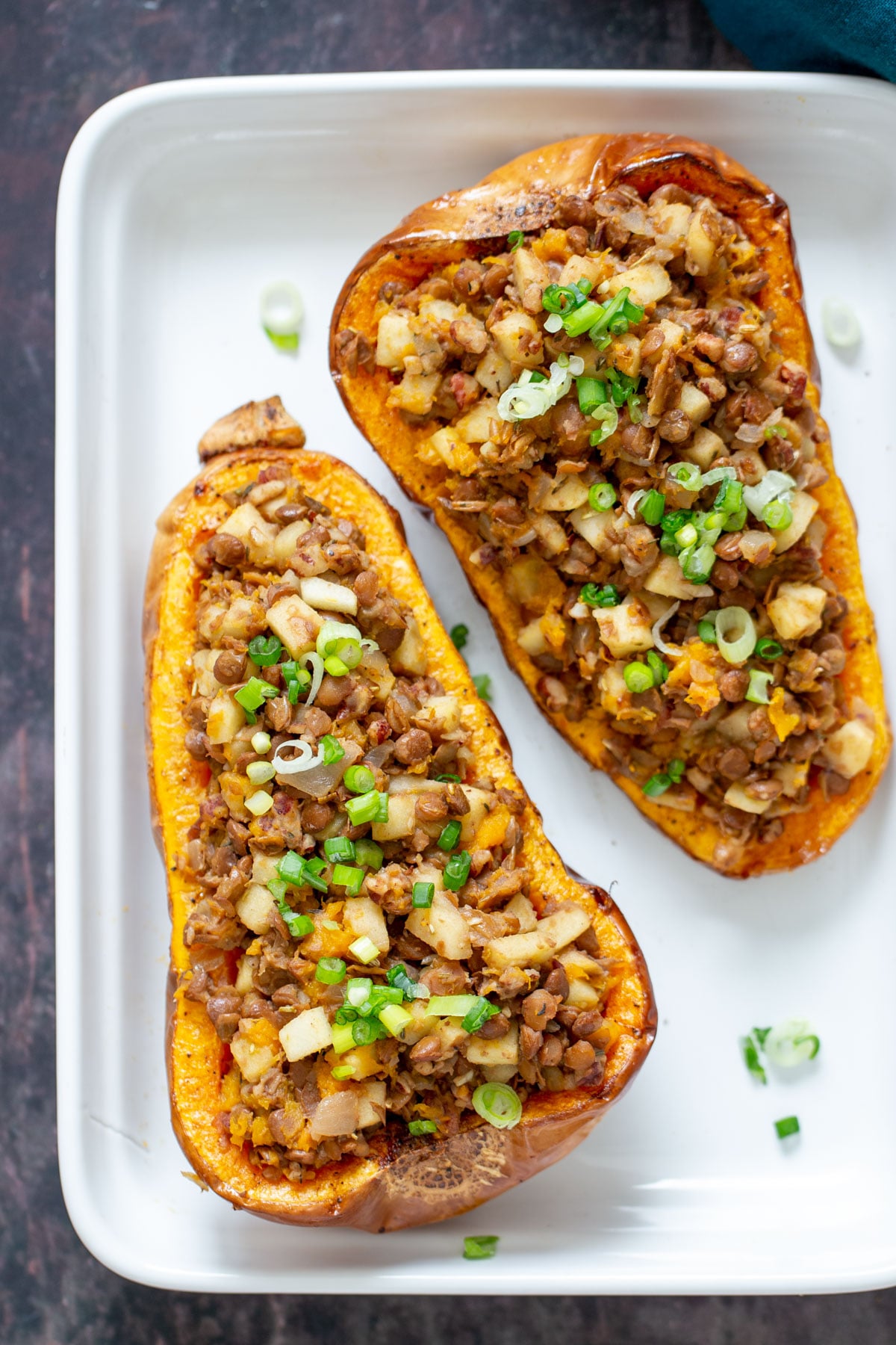 two stuffed butternut squash halves filled with apple and lentil stuffing
