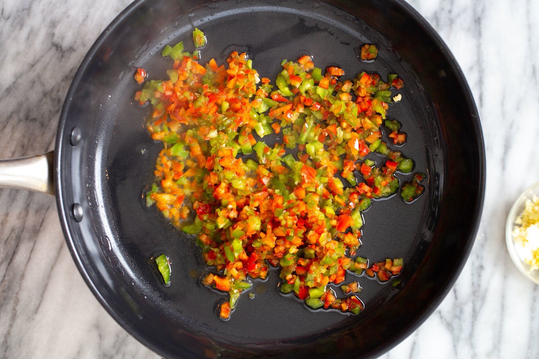 bell pepper cubes frying in a pan to make general tso sauce