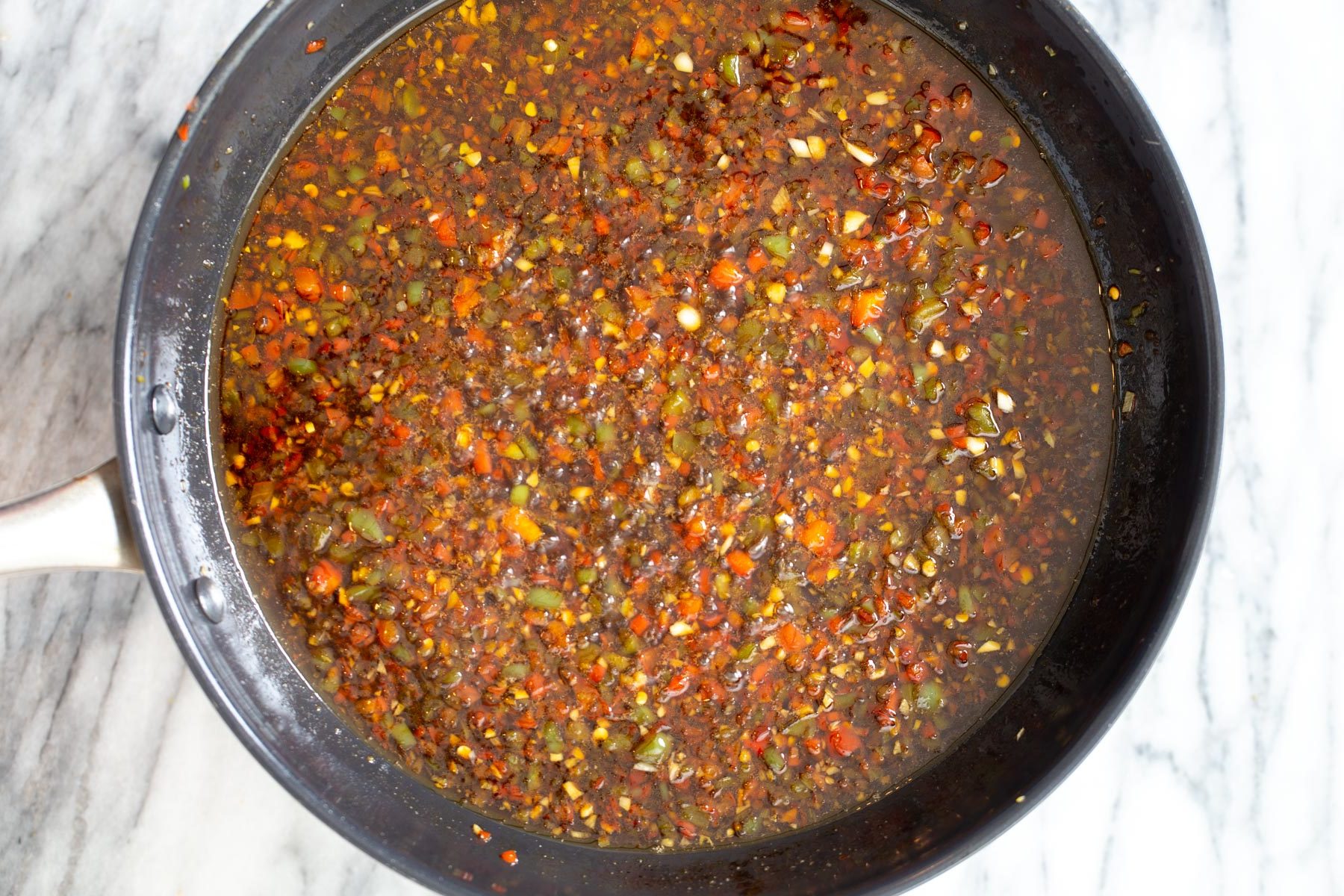 general tso sauce reducing in a frying pan