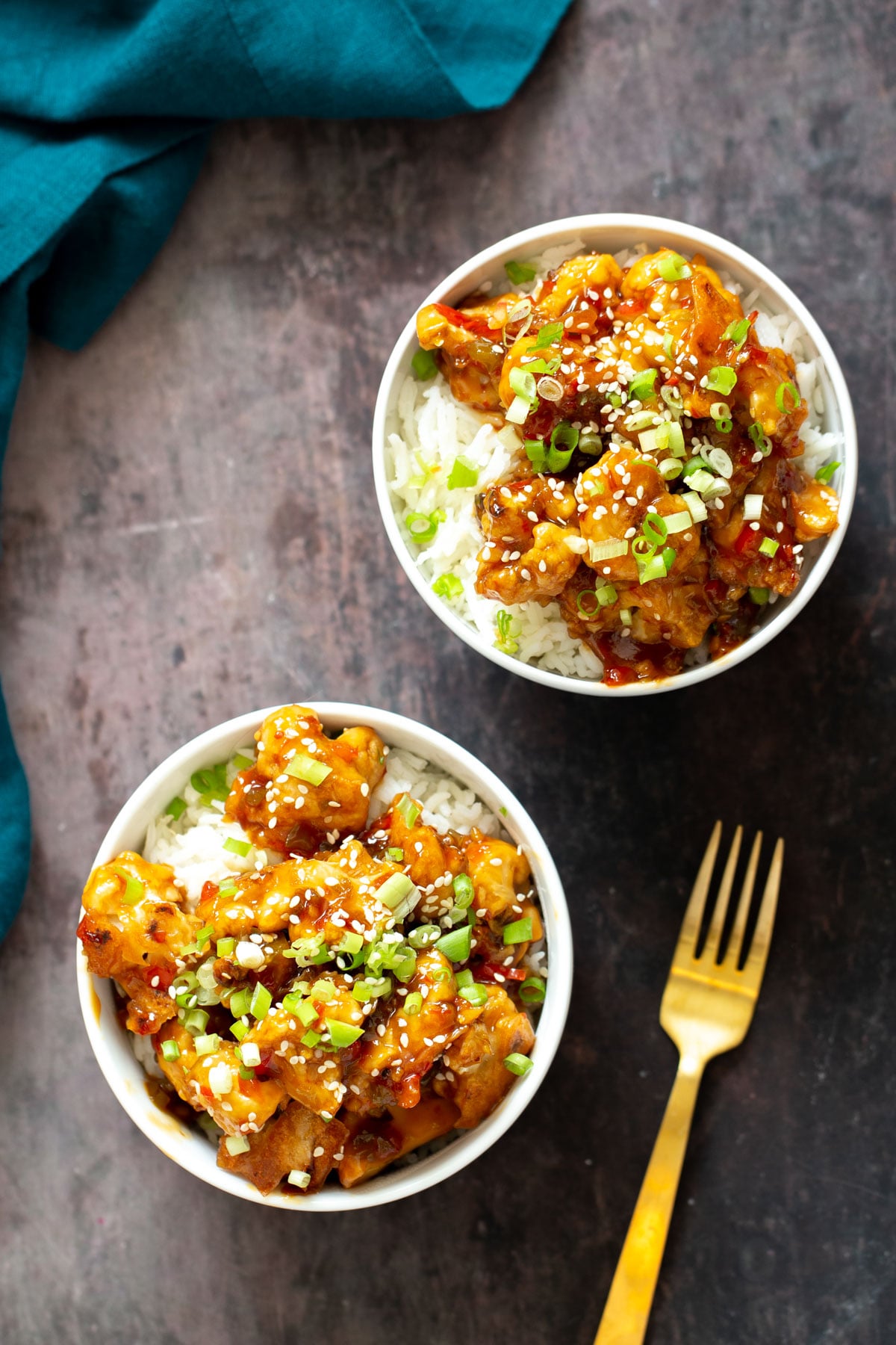 baked vegan general tso cauliflower overhead shot of two servings of vegan general tso cauliflower served on rice