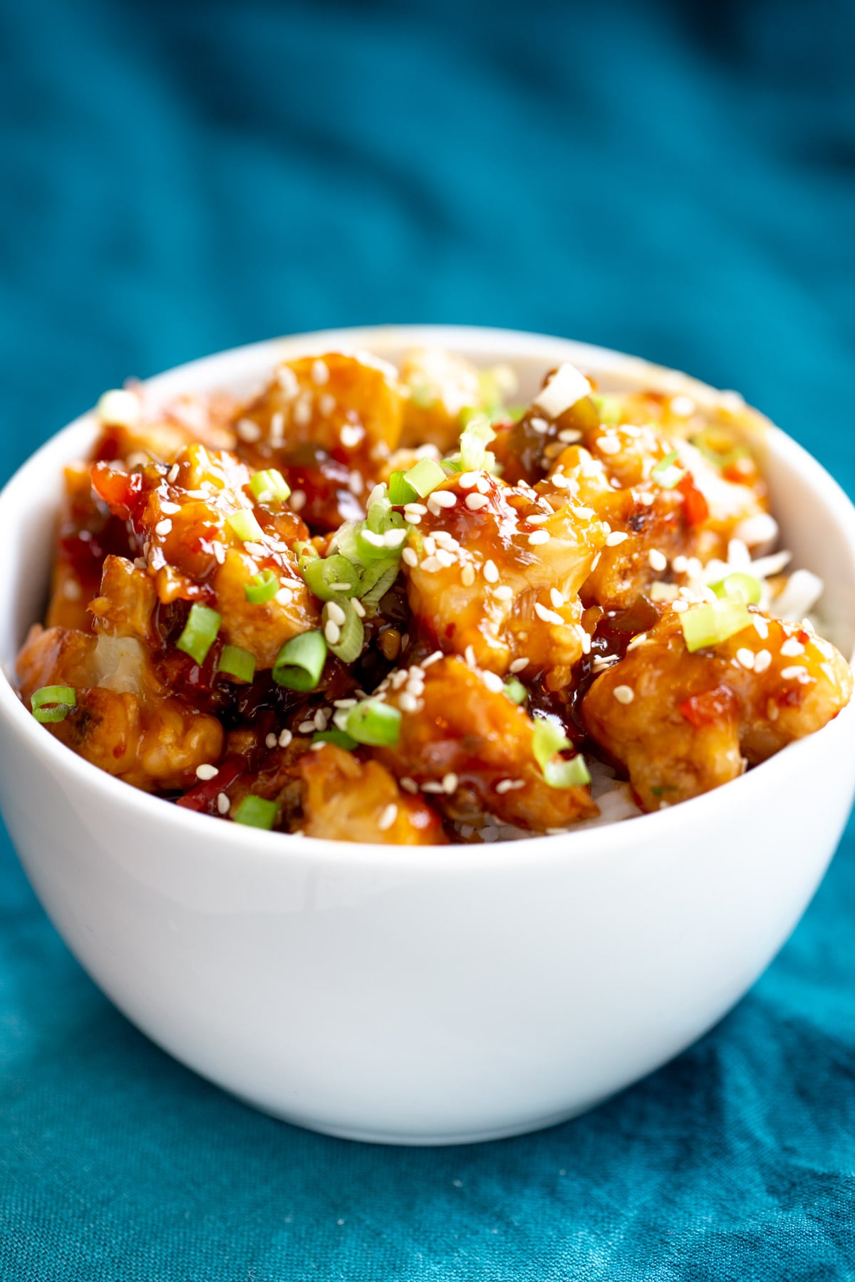 vegan baked general tso cauliflower side view of a bowl of general tso cauliflower