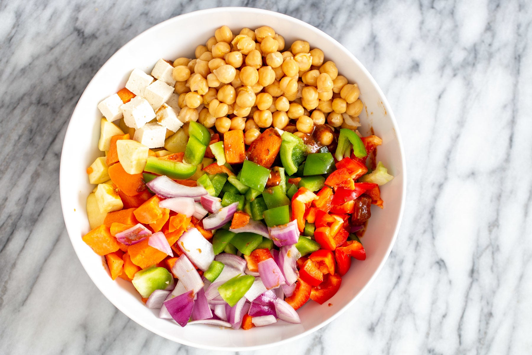 vegetables and tofu cubes in a small white bowl 