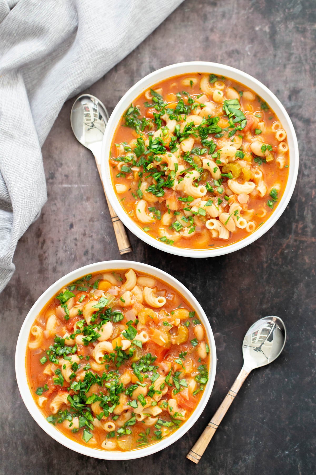 vegan paste e fagioli overhead shot of two bowls of vegan pasta e fagioli garnished with chopped basil