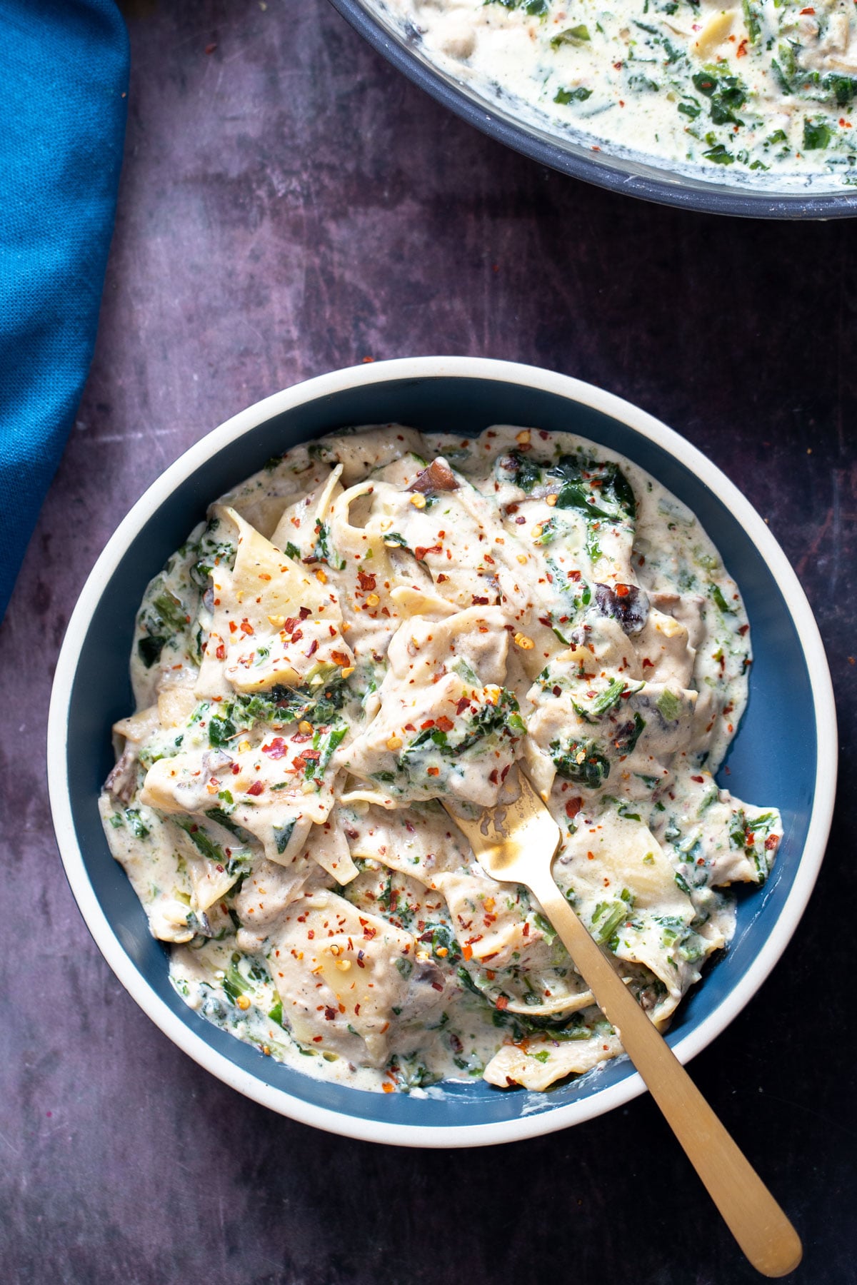 alfredo skillet lasagna a serving of vegan alfredo spinach skillet lasagna on a blue plate