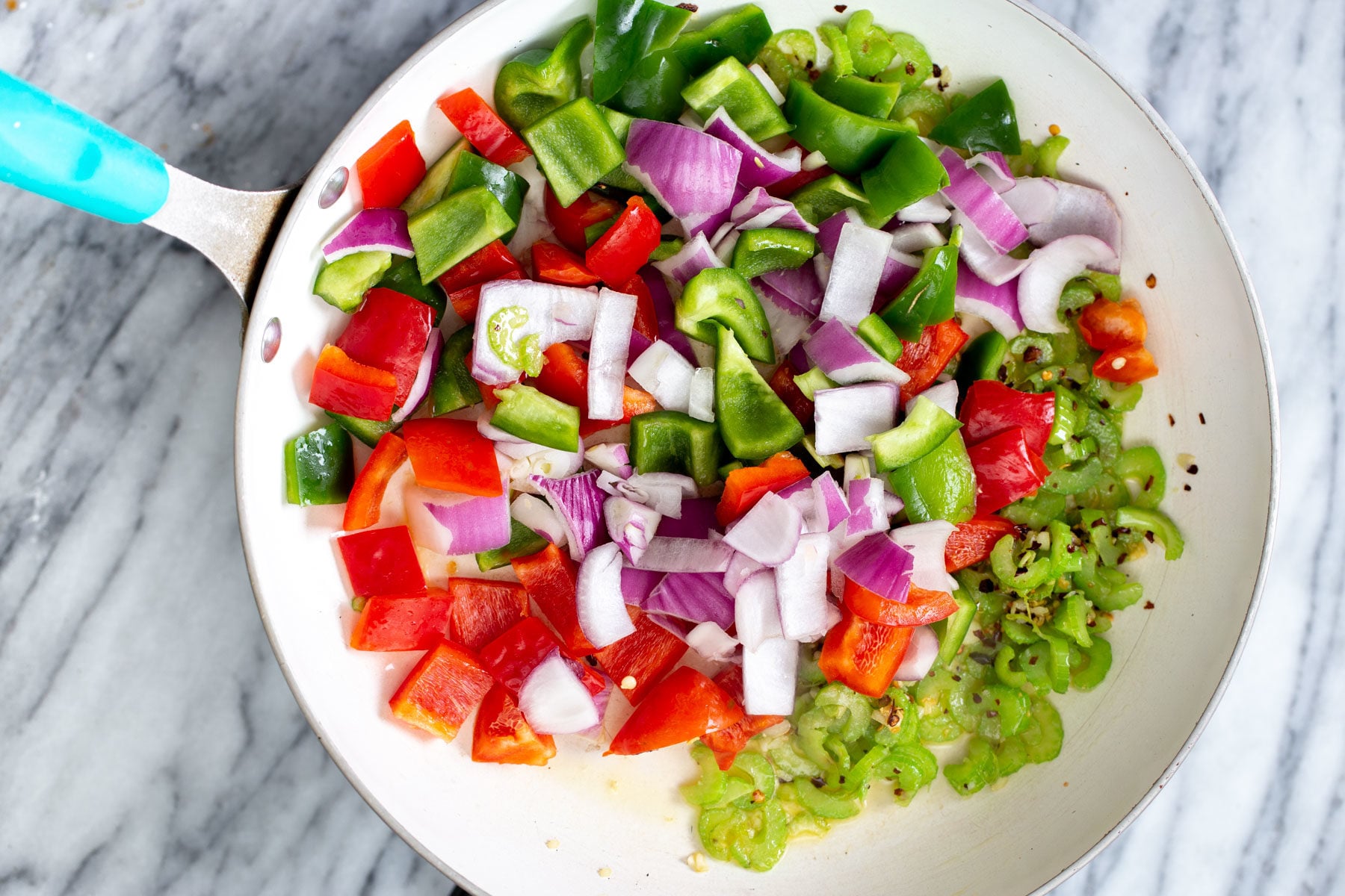 chopped onion and bell pepper in a frying pan