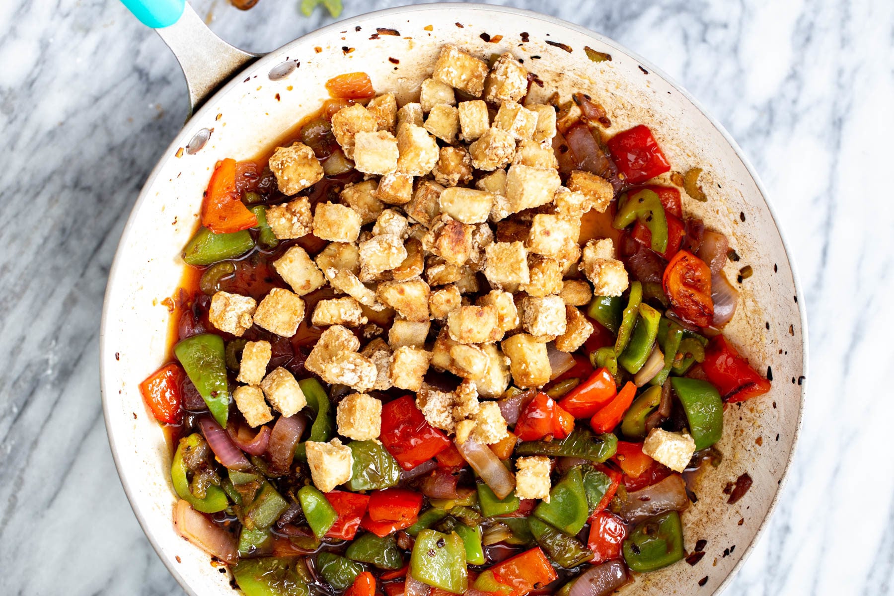baked crispy tofu in being added to a frying pan