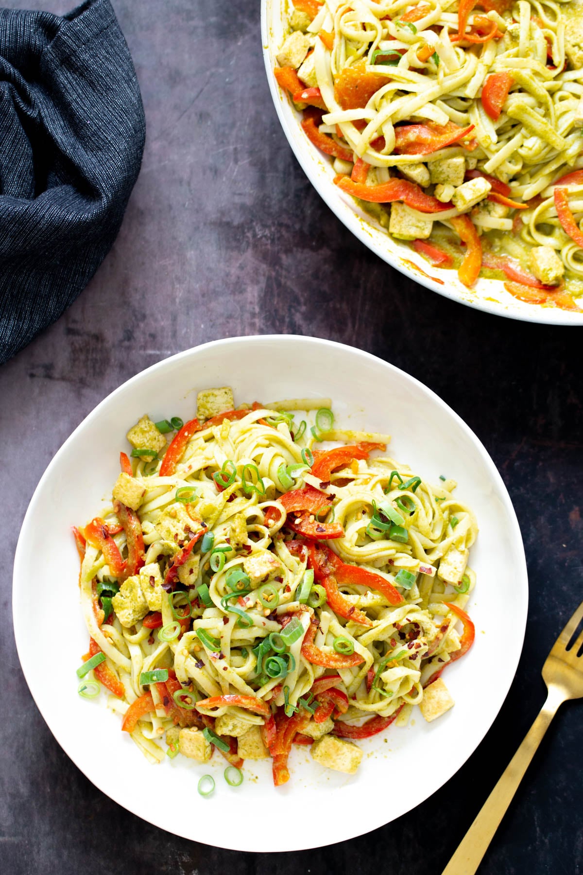 Thai Green Curry Noodles two servings of Thai green curry noodles with bell peppers and green onion with a fork on the side