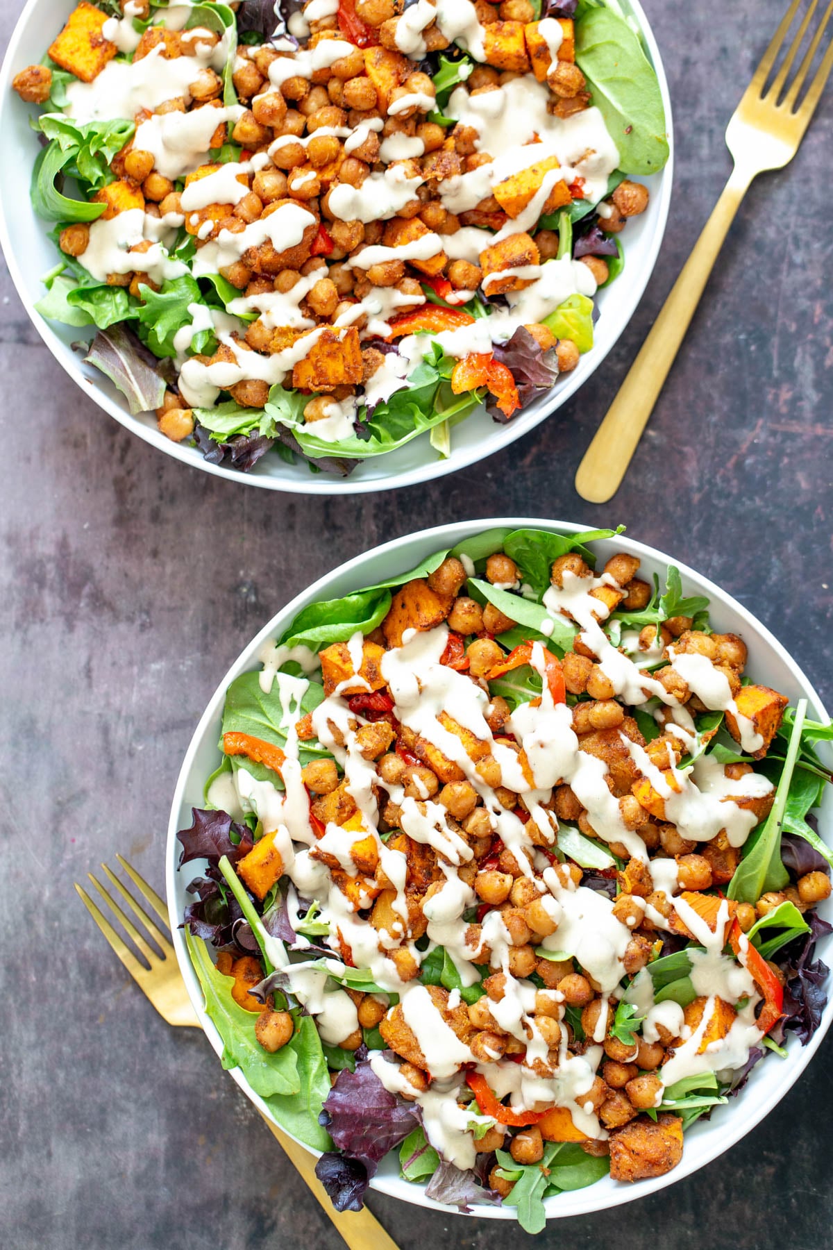 sweet potato chickpea salad two bowls of vegan baked chickpea sweet potato salad bowls drizzled with tahini dressing