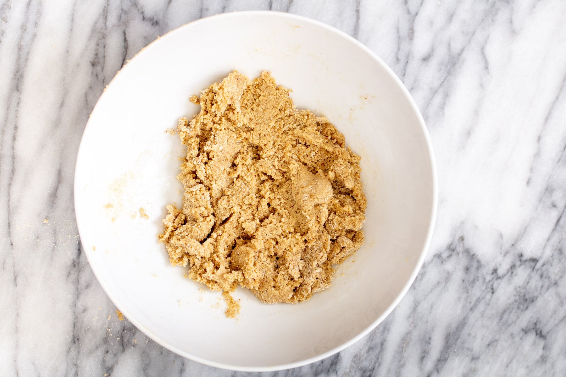 vegan lemon bars vegan cookie crust made from oatmeal and almond flour being mixed in a bowl