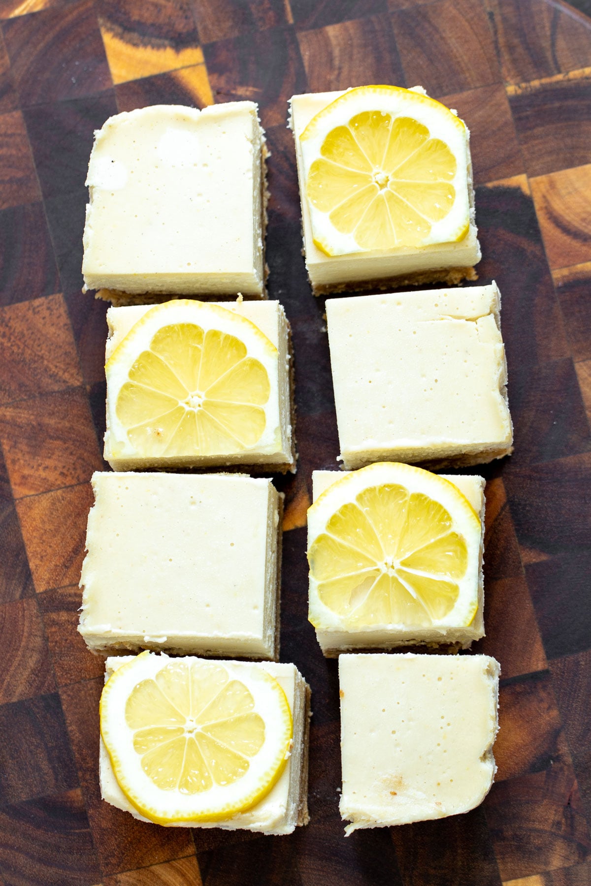 vegan lemon bars vegan lemon bars on a wooden chopping board topped with lemon slices